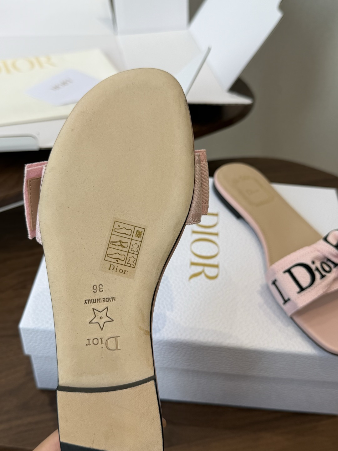 Dior26ss夏季新款字母织带平底一字拖鞋这双拖鞋以品牌标志性的字母织带打造，搭配同色系的皮质鞋床，简