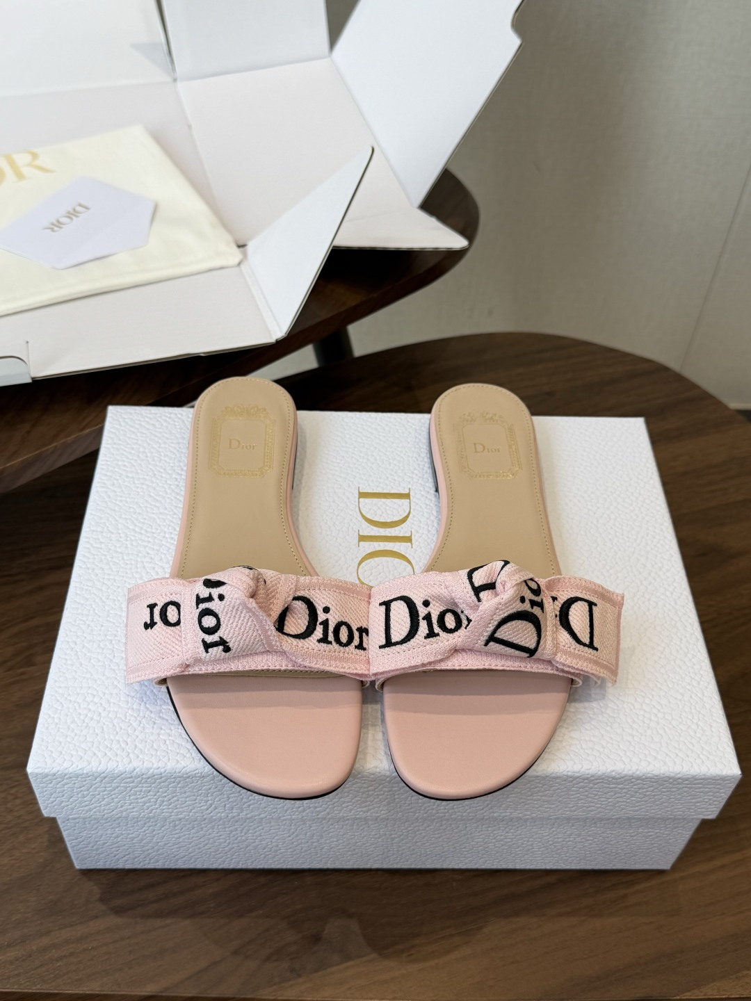 Dior26ss夏季新款字母织带平底一字拖鞋这双拖鞋以品牌标志性的字母织带打造，搭配同色系的皮质鞋床，简