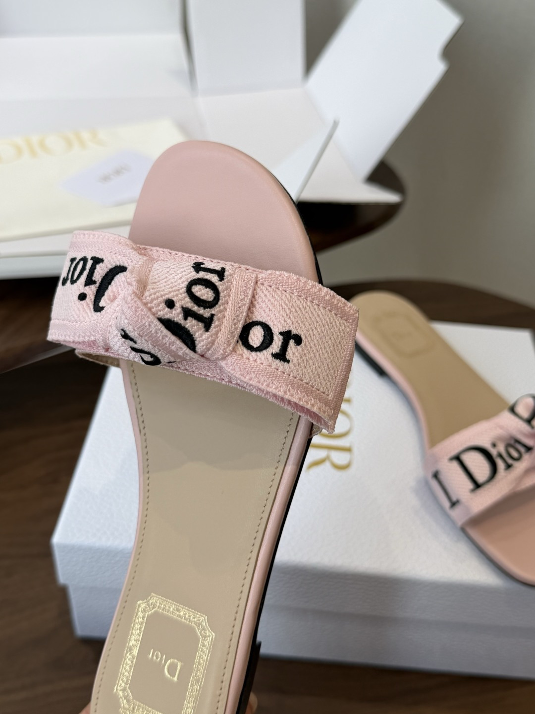 Dior26ss夏季新款字母织带平底一字拖鞋这双拖鞋以品牌标志性的字母织带打造，搭配同色系的皮质鞋床，简