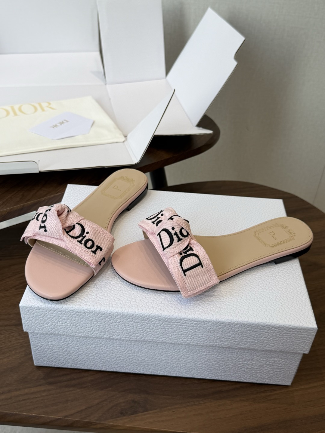 Dior26ss夏季新款字母织带平底一字拖鞋这双拖鞋以品牌标志性的字母织带打造，搭配同色系的皮质鞋床，简