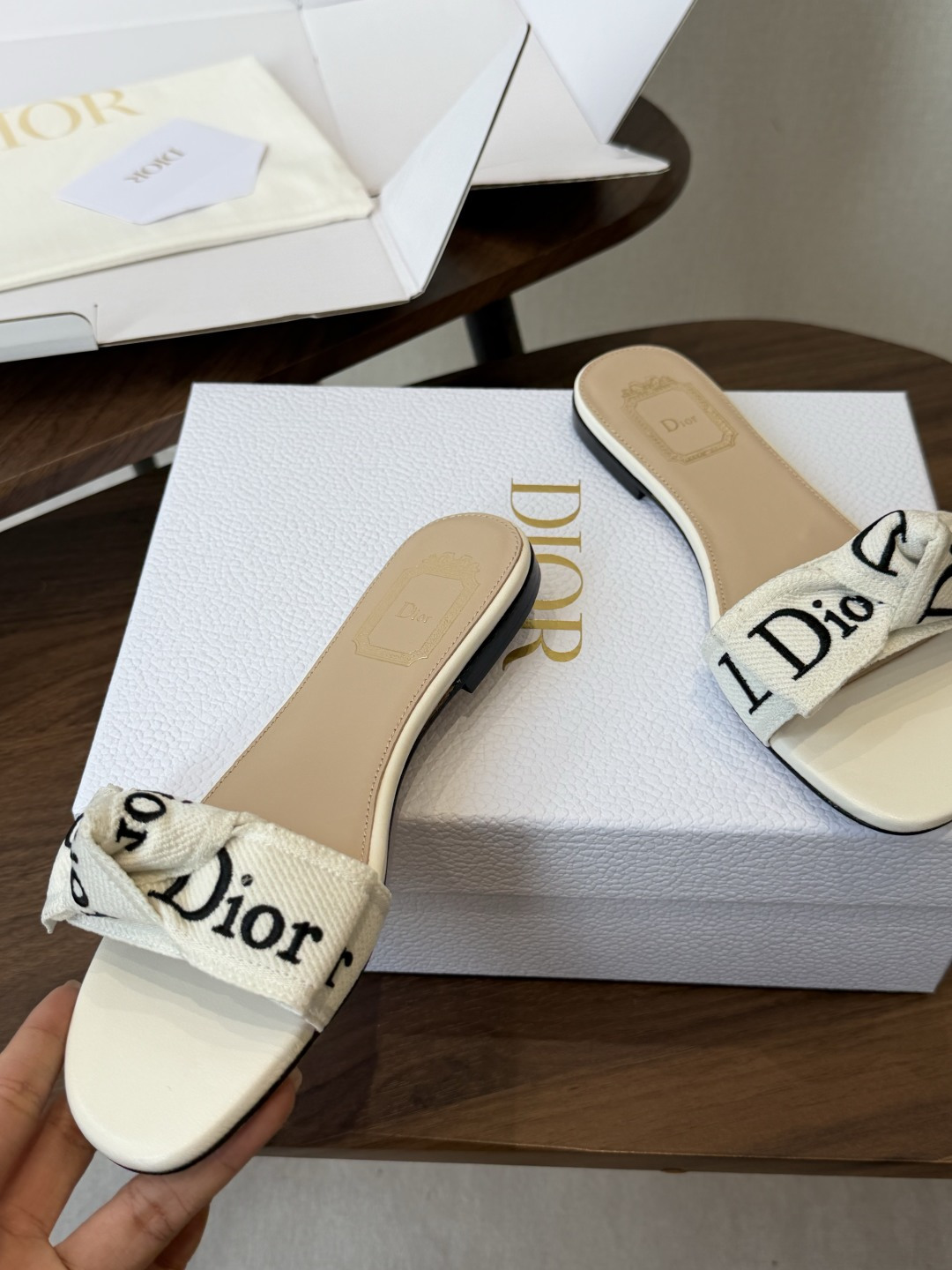 Dior26ss夏季新款字母织带平底一字拖鞋这双拖鞋以品牌标志性的字母织带打造，搭配同色系的皮质鞋床，简