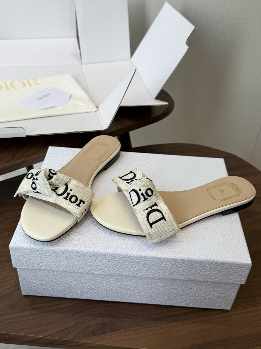 Dior26ss夏季新款字母织带平底一字拖鞋这双拖鞋以品牌标志性的字母织带打造，搭配同色系的皮质鞋床，简