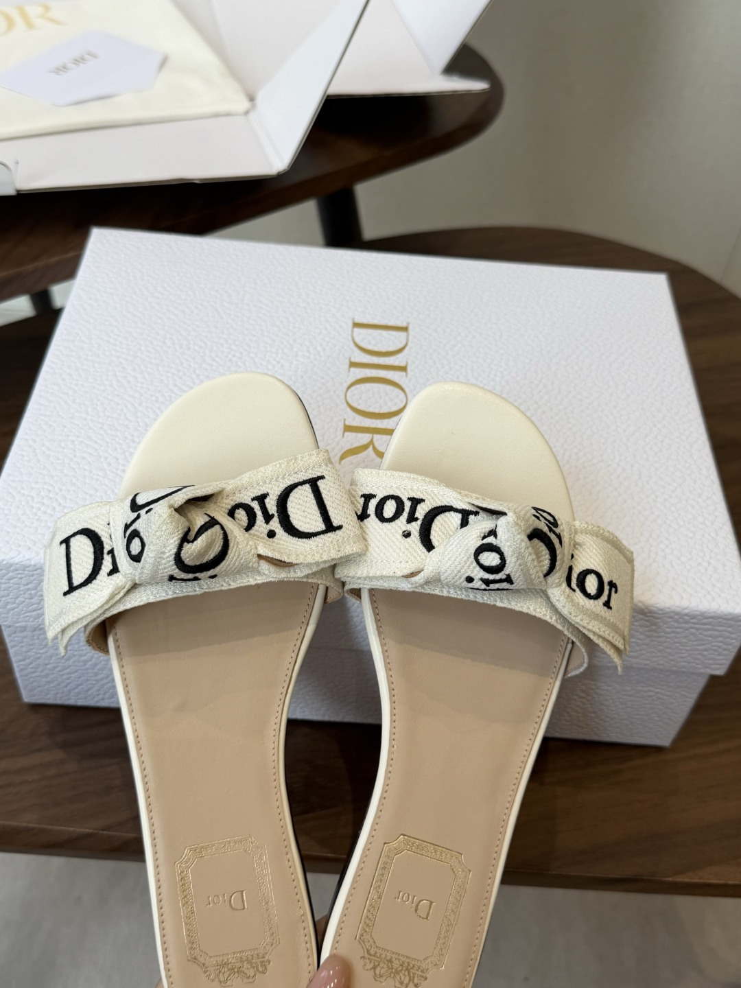 Dior26ss夏季新款字母织带平底一字拖鞋这双拖鞋以品牌标志性的字母织带打造，搭配同色系的皮质鞋床，简