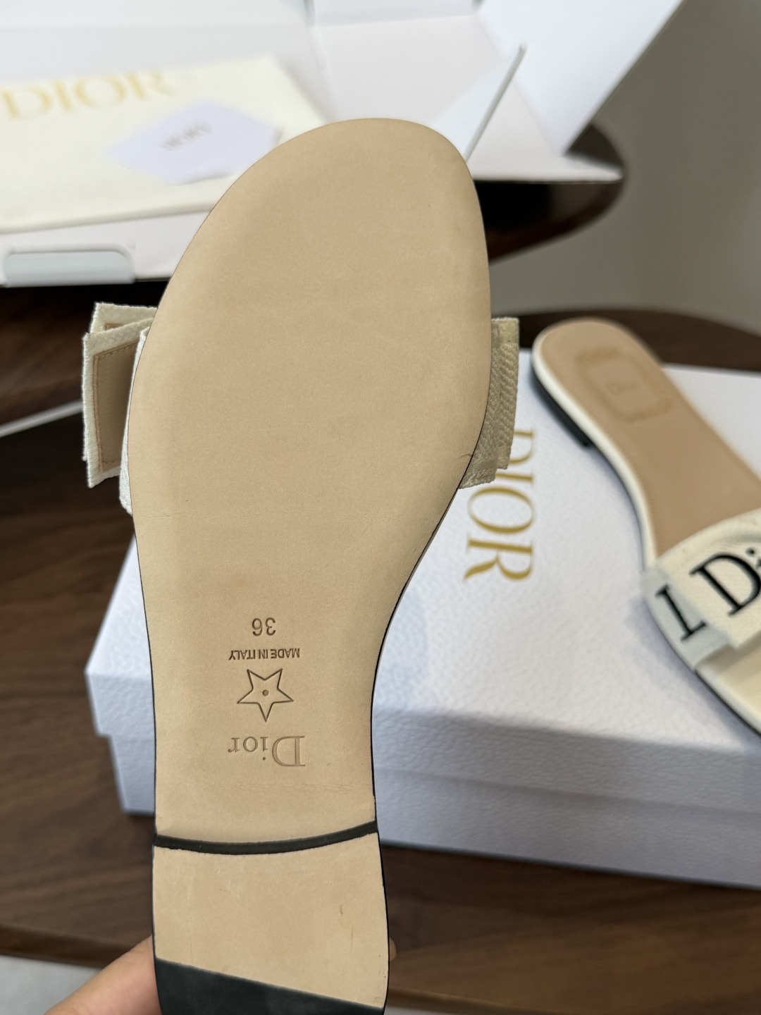 Dior26ss夏季新款字母织带平底一字拖鞋这双拖鞋以品牌标志性的字母织带打造，搭配同色系的皮质鞋床，简