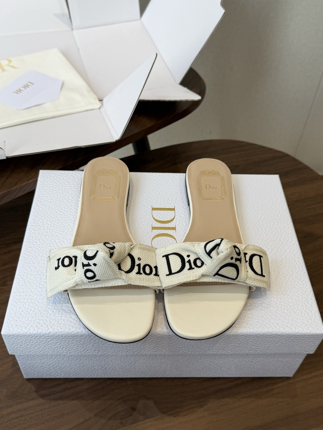 Dior26ss夏季新款字母织带平底一字拖鞋这双拖鞋以品牌标志性的字母织带打造，搭配同色系的皮质鞋床，简