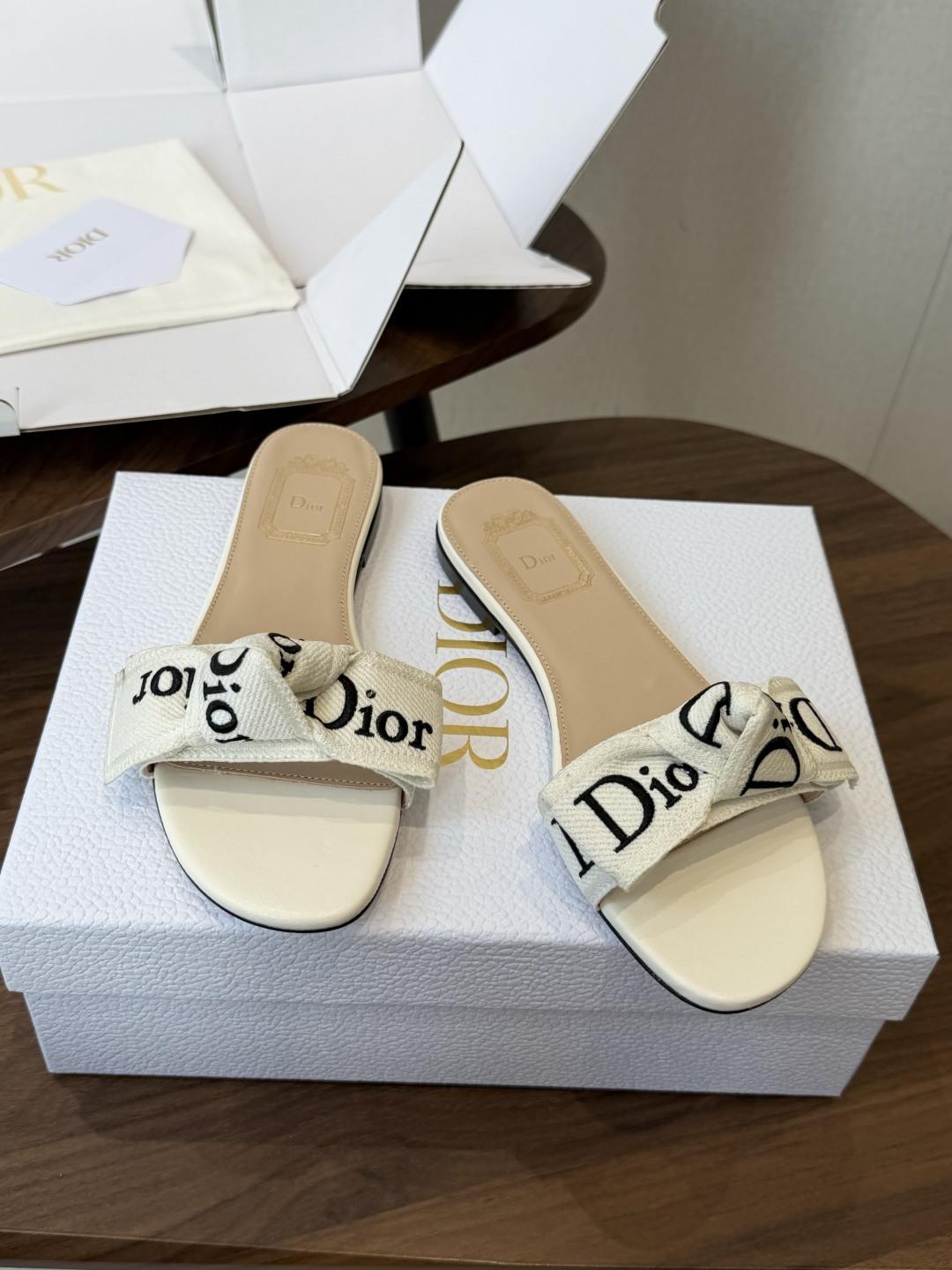 Dior26ss夏季新款字母织带平底一字拖鞋这双拖鞋以品牌标志性的字母织带打造，搭配同色系的皮质鞋床，简