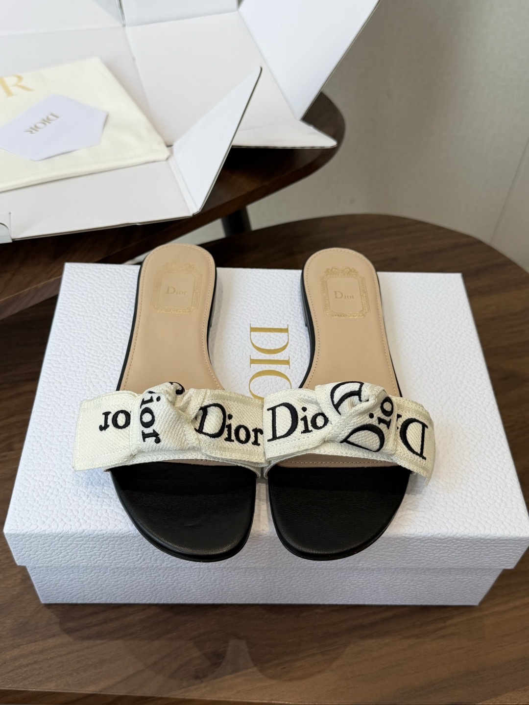 Dior26ss夏季新款字母织带平底一字拖鞋这双拖鞋以品牌标志性的字母织带打造，搭配同色系的皮质鞋床，简