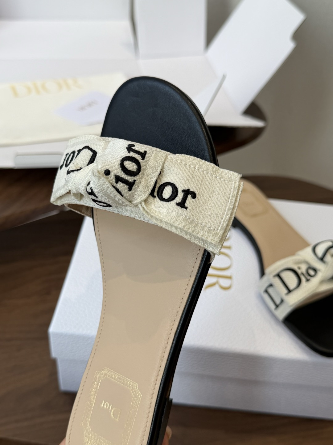 Dior26ss夏季新款字母织带平底一字拖鞋这双拖鞋以品牌标志性的字母织带打造，搭配同色系的皮质鞋床，简