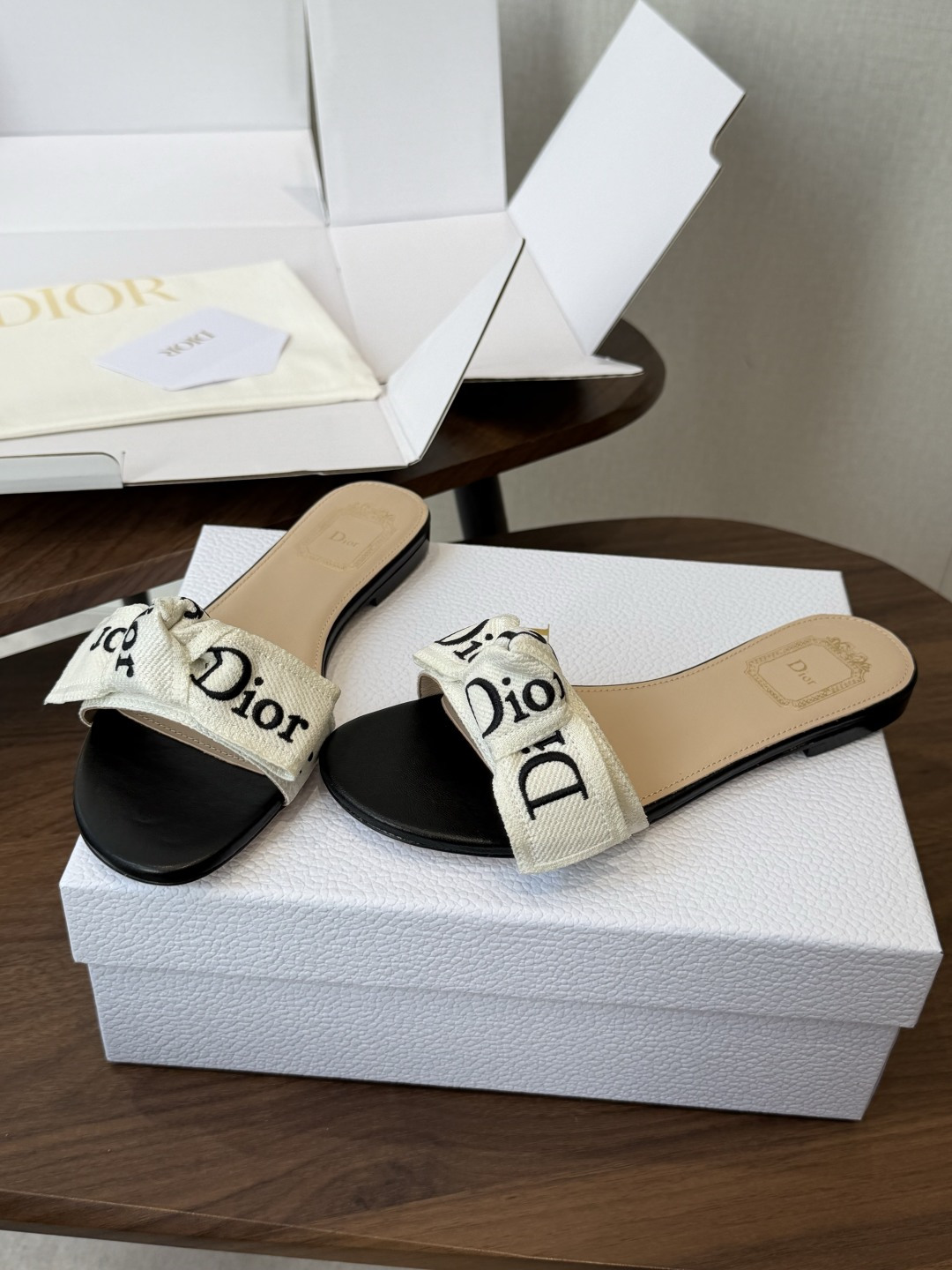 Dior26ss夏季新款字母织带平底一字拖鞋这双拖鞋以品牌标志性的字母织带打造，搭配同色系的皮质鞋床，简