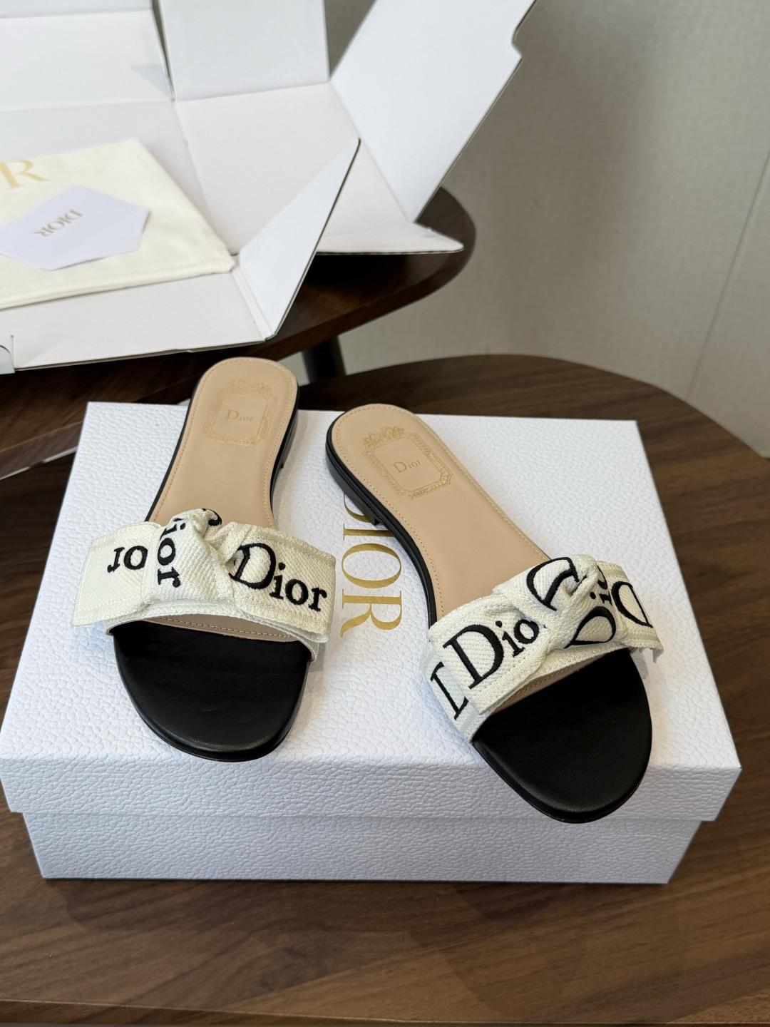 Dior26ss夏季新款字母织带平底一字拖鞋这双拖鞋以品牌标志性的字母织带打造，搭配同色系的皮质鞋床，简