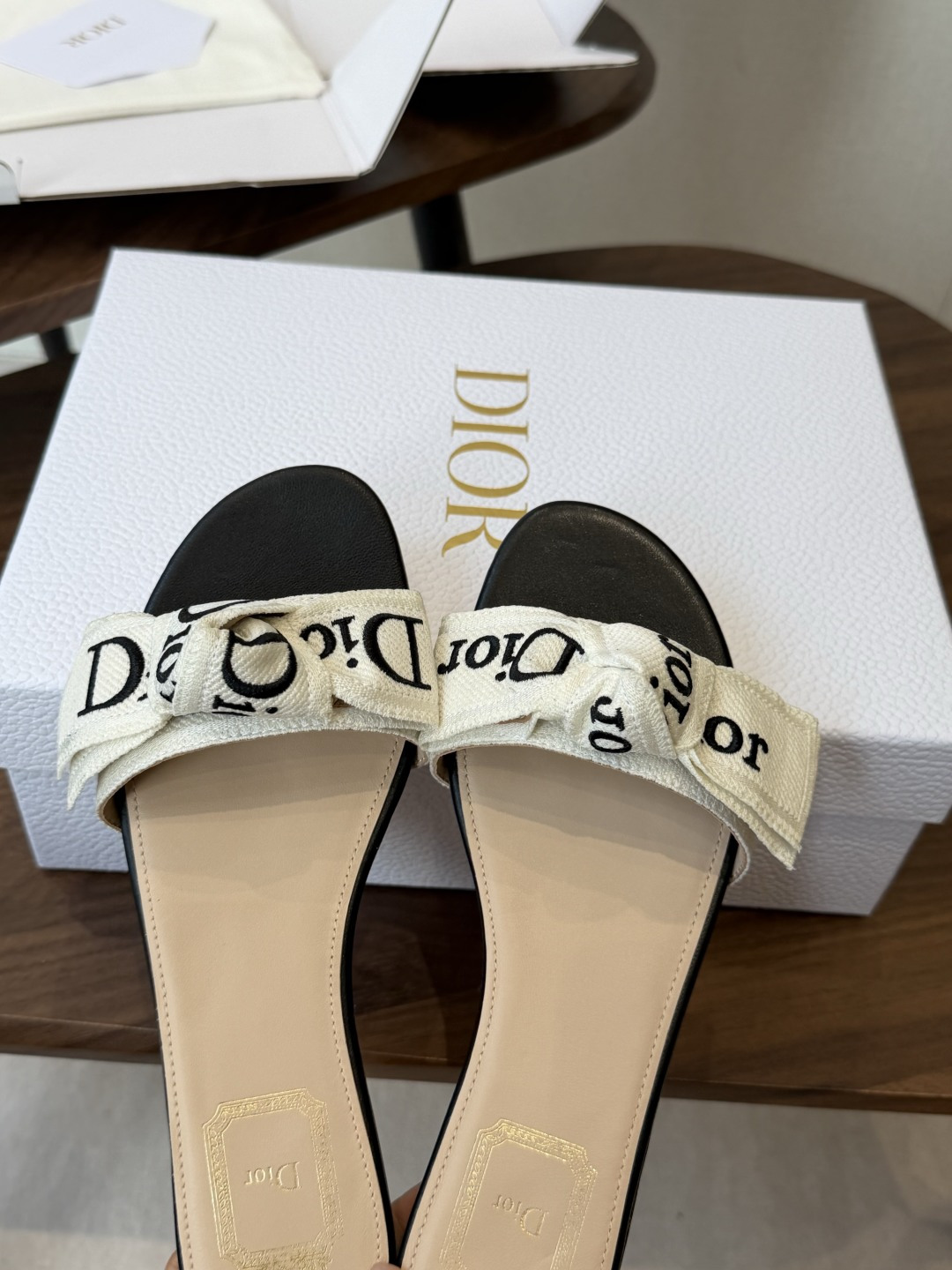 Dior26ss夏季新款字母织带平底一字拖鞋这双拖鞋以品牌标志性的字母织带打造，搭配同色系的皮质鞋床，简