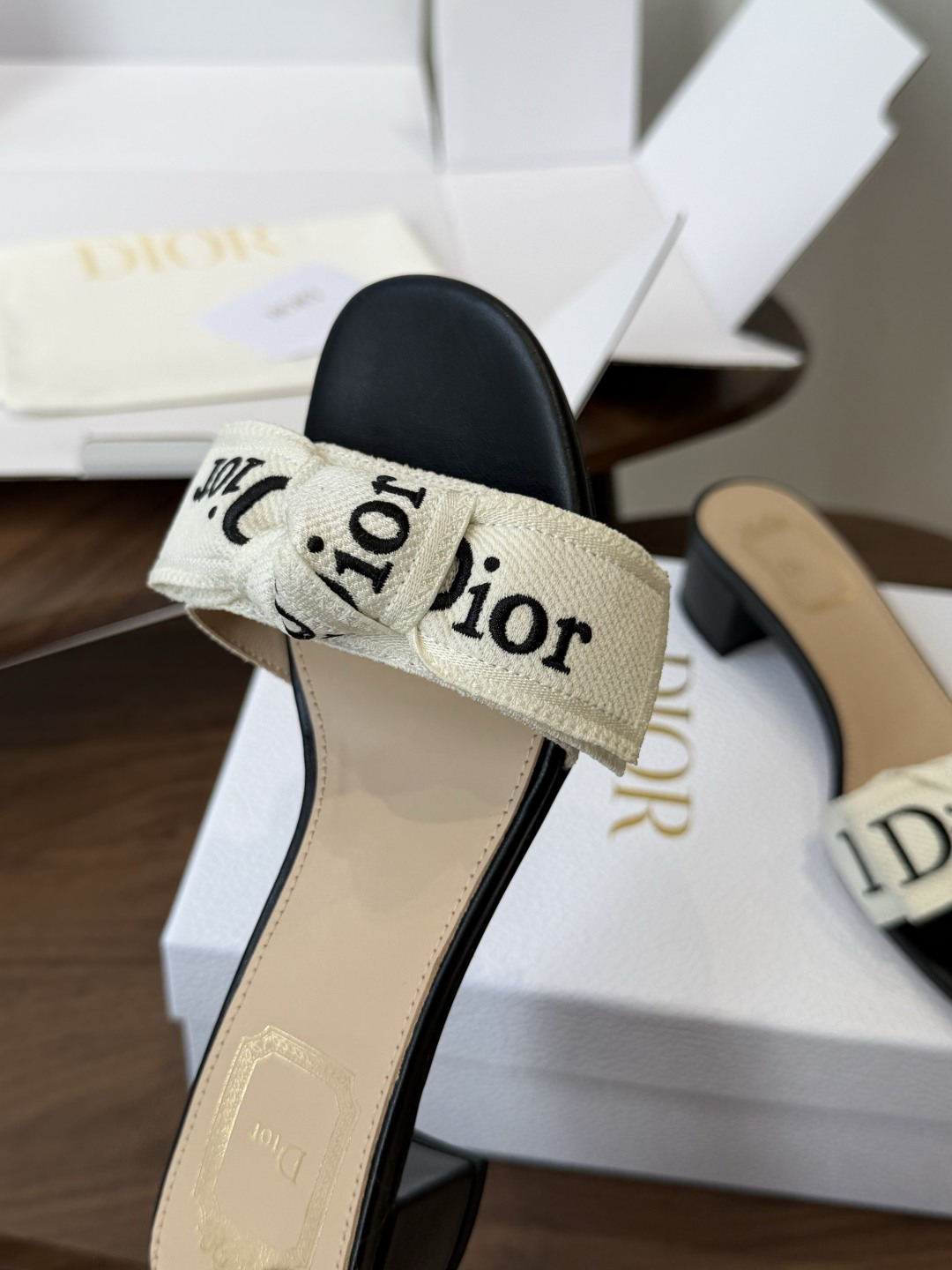 Dior26ss夏季新款字母织带平底一字拖鞋这双拖鞋以品牌标志性的字母织带打造，搭配同色系的皮质鞋床，简