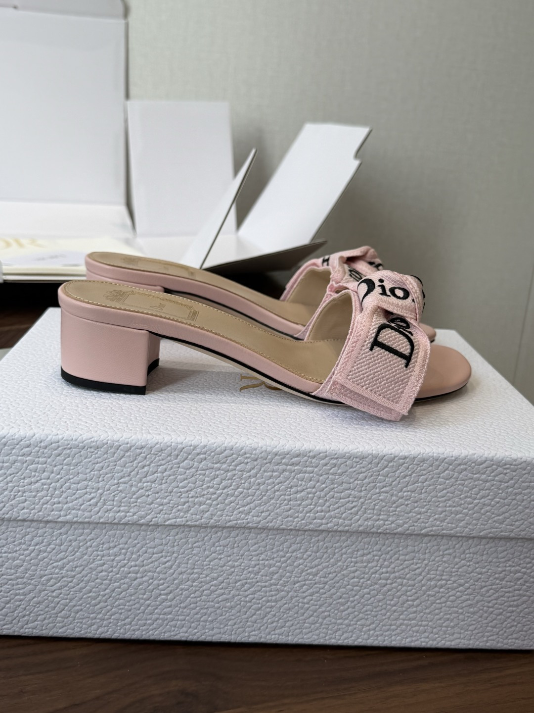 Dior26ss夏季新款字母织带平底一字拖鞋这双拖鞋以品牌标志性的字母织带打造，搭配同色系的皮质鞋床，简