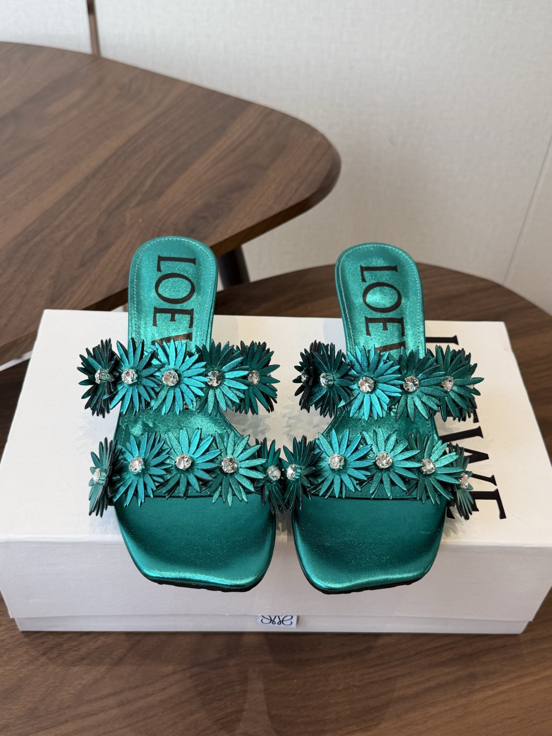 NO:924271,The top version of LOEWE 26ss summer new rhinestone transparent square toe one-line sandals. This pair of one-line sandals opens up the summer sophistication with its neat square toe silhouette. The transparent upper is studded with three-dimensional rhinestone flowers, and the blue rhinestones in the center are like fine starlight. Every step brings a smart luster, gentle and dazzling. It is suitable for different styles of wear and comes with a high-end soft light filter.  The ingenuity in the details shows the texture. The clear LOEWE logo inside the shoe is matched with exquisite metal accessories. The rhinestones are arranged tightly and firmly and are not easy to fall off. The edges of the square head are polished smoothly without unnecessary rough edges and corners. The low-heeled design combines elegance and practicality and is stable for daily walking. Upper film/diamond Inner sheepskin outsole Original outsole  size 35-41 (customized sizes 40 and 41 are not returnable), slippers, loewe, sandals, slippers, sheepskin19860909顶级版本 LOEWE 26ss夏季新款水钻透明方头一字凉拖鞋 这双一字拖凉鞋,以利落的方头廓形开启夏日精致感,透明鞋面上缀满立体水钻花朵,中心点缀的蓝调水钻如同细碎星光,每一步都带着灵动的光泽感,温柔又耀眼.适配不同风格的穿搭,自带高级柔光滤镜. 细节处的巧思更见质感,鞋内清晰的LOEWE标识,搭配精致的金属饰件,水钻排列紧密牢固,不易脱落,方头的边缘打磨光滑,没有多余的毛边和棱角,低跟的设计兼顾了优雅与实用性,日常走路也能稳稳当当. 鞋面胶片/钻 内里羊皮 大底原版大底 size35-41码（40、41码定制不退换）,拖鞋,loewe,sandals,slippers,sheepskin,Women's Shoes