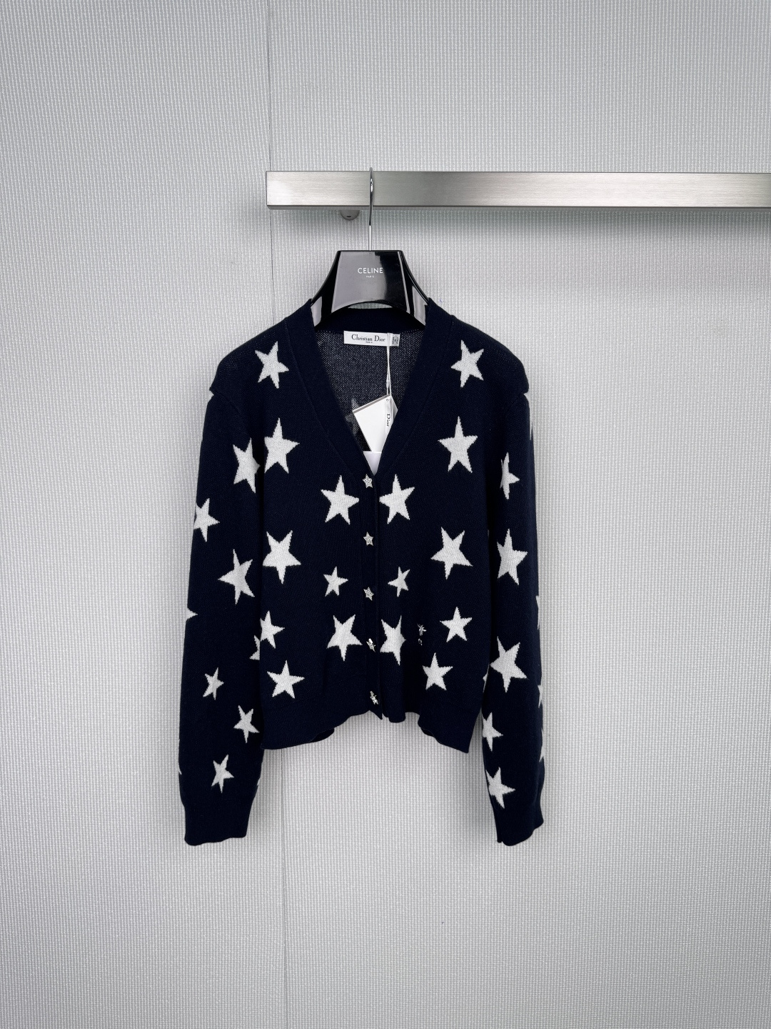 NO:578200,Dior's new 2025 autumn and winter V-neck cardigan is embellished with stars, interpreting French fashion style. It is an indispensable fashion tool in the wardrobe - this Dior  The V-neck cardigan outlines an extraordinary temperament with simple tailoring. The light gray/off-white background is like a quiet canvas, and black stars of different sizes are scattered freely, instantly breaking the dullness of the basic style, giving the whole body a smart and elegant sense of breathing. The iconic starry sky element, the patchwork jacquard star pattern, has both visual tension and brand recognition, and perfectly interprets Dior's aesthetic code of coexistence of classics and new trends. The elegant V-neck tailoring effectively modifies the neck and face lines.  , it can be layered with a shirt, a T-shirt or worn directly, and can be easily layered to create a lazy and neat layering. It is made of fine and soft knitted material, combined with ribbed edges on the cuffs and hem, and textured buttons, showing ingenuity in every detail. Whether it is paired with high-waisted jeans to interpret the casual fashion of the Left Bank of Paris, or combined with skirts and suit pants for commuting and dating occasions, a cardigan can achieve a seamless switch between elegance and playfulness, becoming the finishing touch of the overall look.  Size SML,,dior,skirts,jeans,shirts,tees,t-shirt,business suit,alexander wang19860909Dior2025秋冬新款 V领开衫繁星点缀,演绎法式时髦型格,衣橱里不可或缺的时髦利器——这件Dior V领开衫,以简约剪裁勾勒出不凡气质,浅灰/米白底色如静谧画布,任大小不一的黑色星星肆意洒落,瞬间打破基础款的沉闷,赋予整体灵动而优雅的呼吸感,标志性星空元素,错落有致的提花星星图案,兼具视觉张力与品牌辨识度,完美诠释Dior经典与新潮并存的美学密码,优雅V领剪裁,有效修饰颈部与脸部线条,可内搭衬衫、T恤或直接穿着,轻松叠穿出慵懒而利落的层次感,细腻柔软的针织材质,结合袖口与下摆的罗纹收边,以及质感纽扣,于细节处尽显匠心,无论是搭配高腰牛仔裤演绎巴黎左岸的休闲风尚,还是与半裙、西装裤结合出入通勤与约会场合,一件开衫即可实现优雅与俏皮的无缝切换,成为整体造型的点睛之笔. 码数SML,,dior,skirts,jeans,shirts,tees，t-shirt,business suit,alexander wang,Women's clothing
