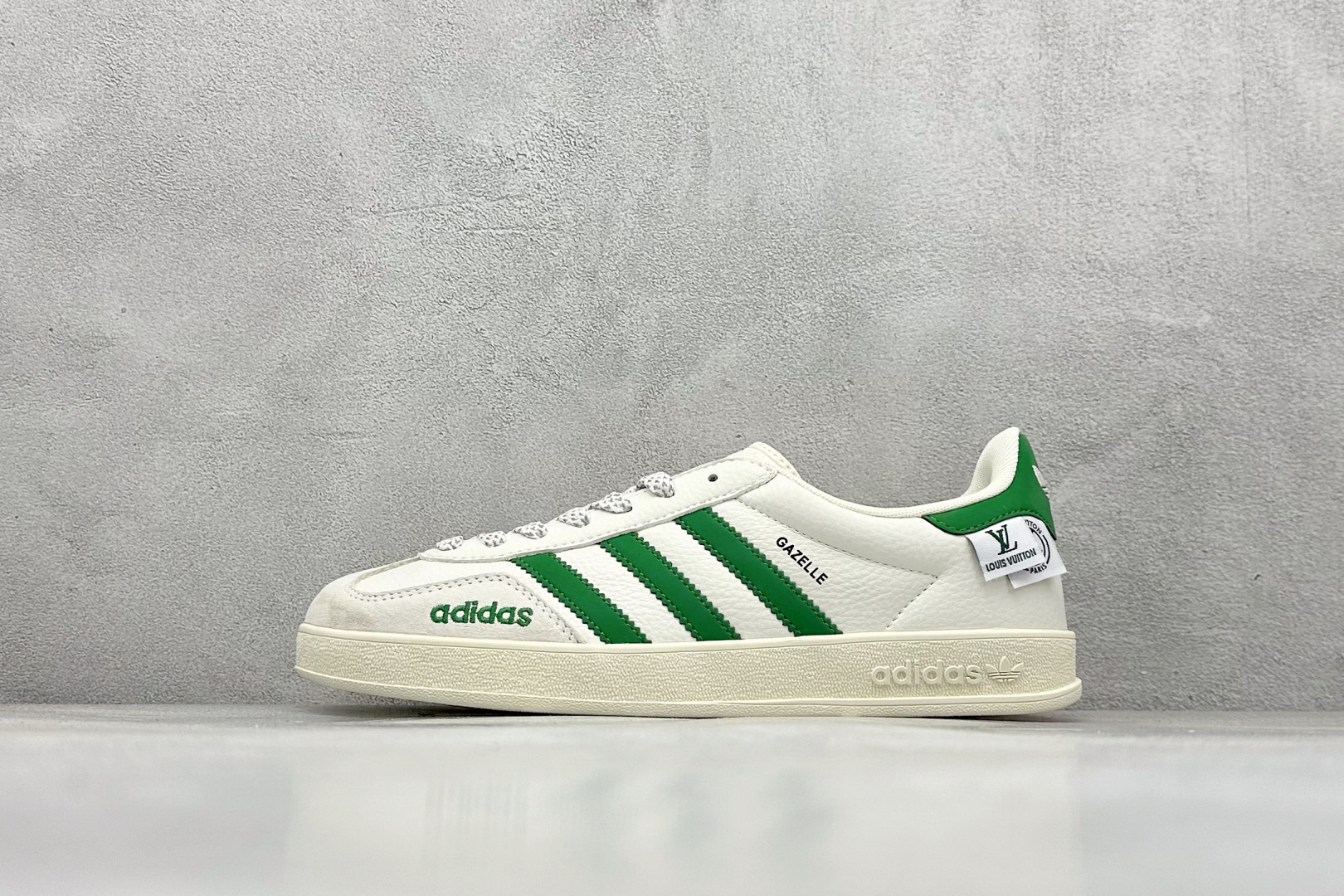 adidas originals GAZELLE INDOOR IndoorSUP T头鞋 LV联名 防滑耐磨轻便 低帮 板鞋 男女同款 白绿 以柔软的皮革鞋面搭配耐磨橡胶外底，展现出复古与现代的融合。鞋面采用细腻纹理设计，搭配军绿三条杠，尽显品牌经典。无论是运动场还是街头，这双鞋都能轻松驾驭。 货号： XD6188-102 尺码： 36 36.5 37 38 38.5 39 40 40.5 41 42 42.5 43 44 44.5 45-选品中心