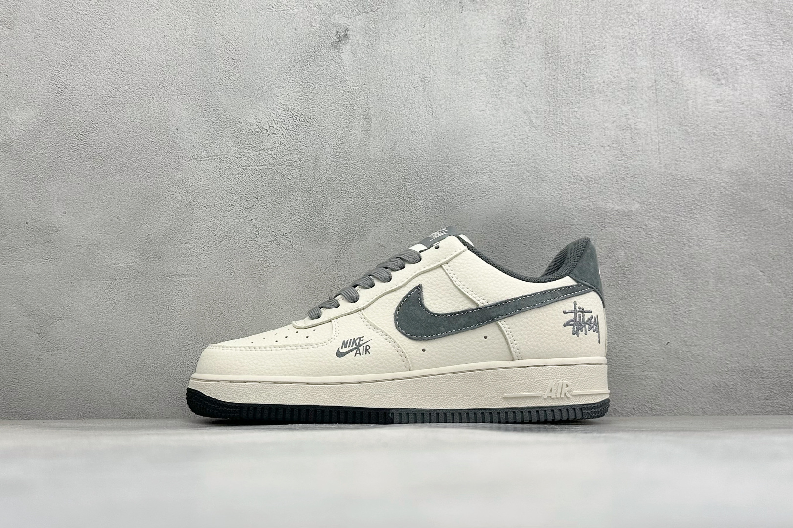 潮牌联名质感拉满 AIR FORCE 1 以米白皮革拼接黑色细节，搭配Stüssy标志性涂鸦Logo与金属挂饰，街头属性
