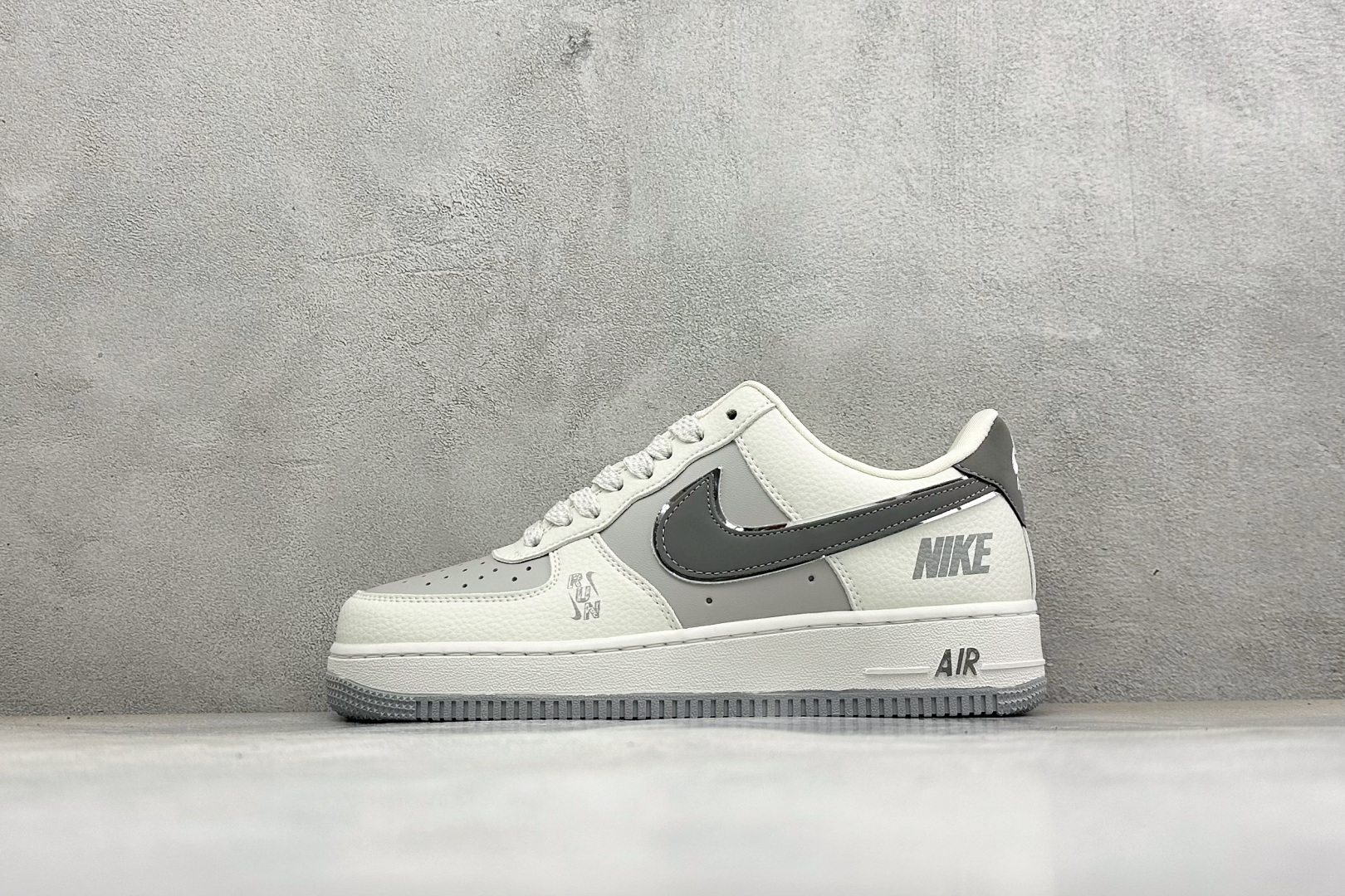 潮酷质感上脚出圈 AIR FORCE 1，这款空军一号低帮板鞋采用白灰撞色皮革拼接打造，层次质感出众，深灰Swoosh搭