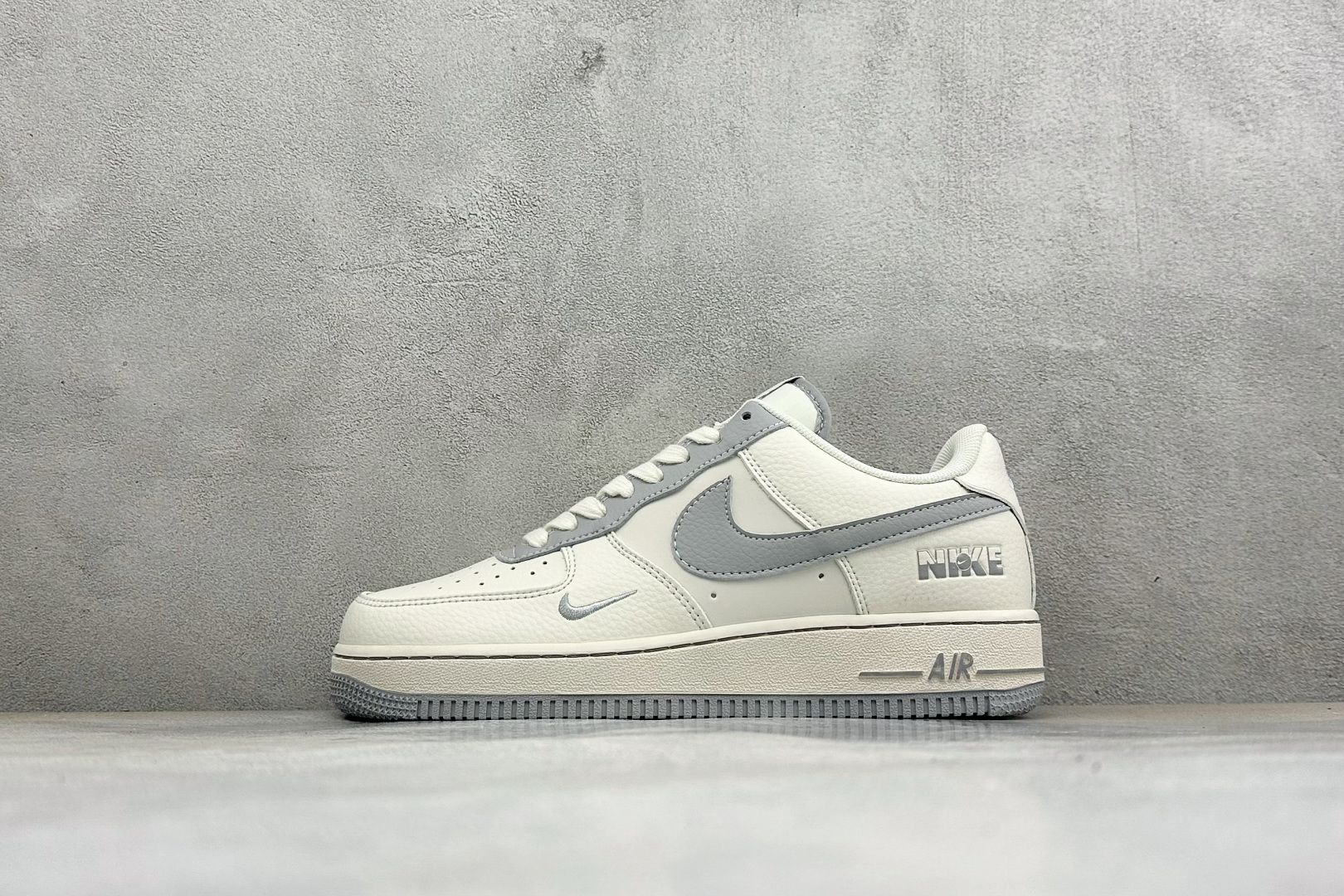 潮搭首选 质感出众 AIR FORCE 1，经典空军一号低帮版型打造，米白基底搭配灰色双勾设计，自带专属金属吊牌点缀，层