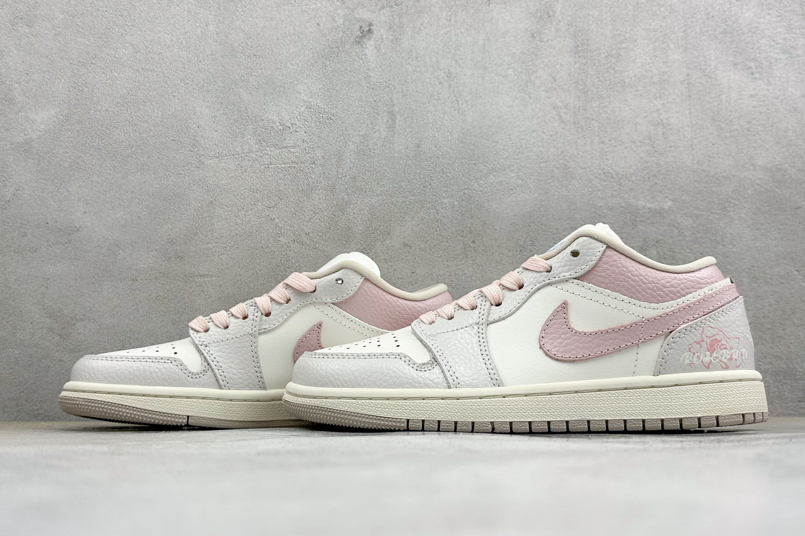 温柔甜妹颜值封神 AIR JORDAN 1，低帮简约鞋型搭配浅灰粉白柔和配色，细腻皮质质感出众，鞋后跟玫瑰刺绣精致浪漫，