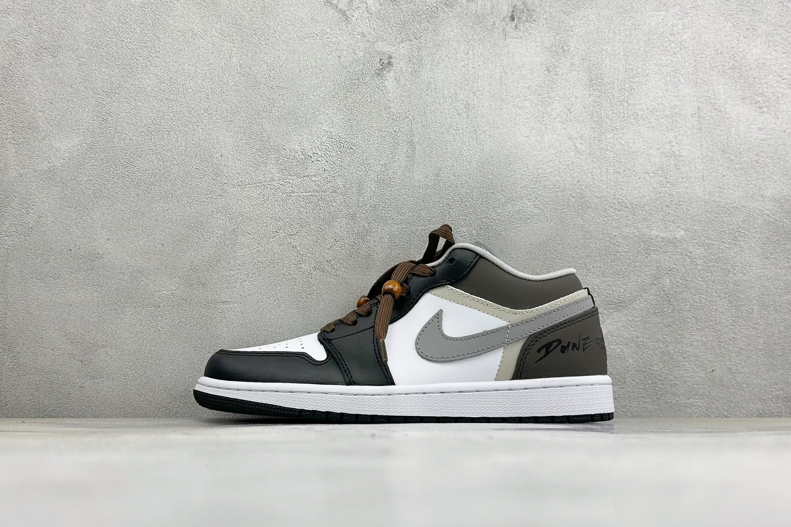 AIR JORDAN 1 LOW 经典AJ1低帮版型，优质皮革鞋面，黑白撞色基底搭配深棕饰块，层次丰富质感在线。侧边灰色