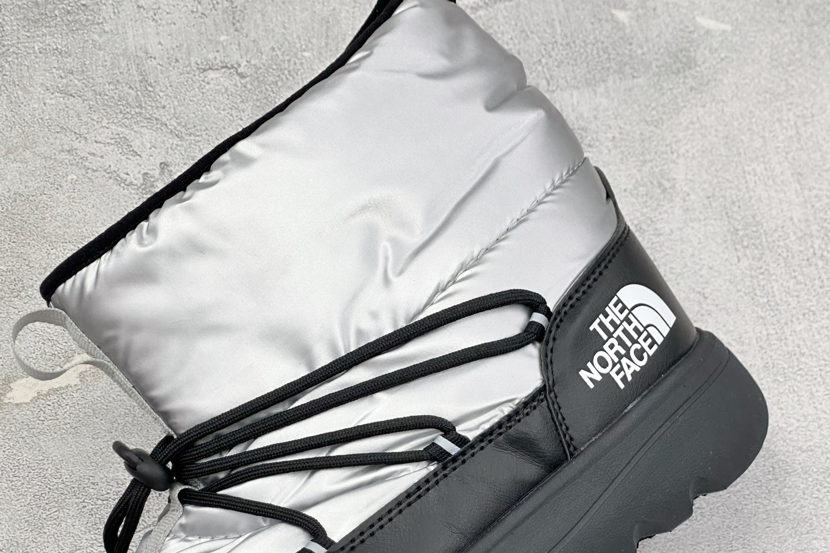 The North Face 北面高帮雪地靴，格纹尼龙防泼水面料，内里加厚绒毛，锁温保暖。快速抽绳锁扣设计，穿脱便捷，牢