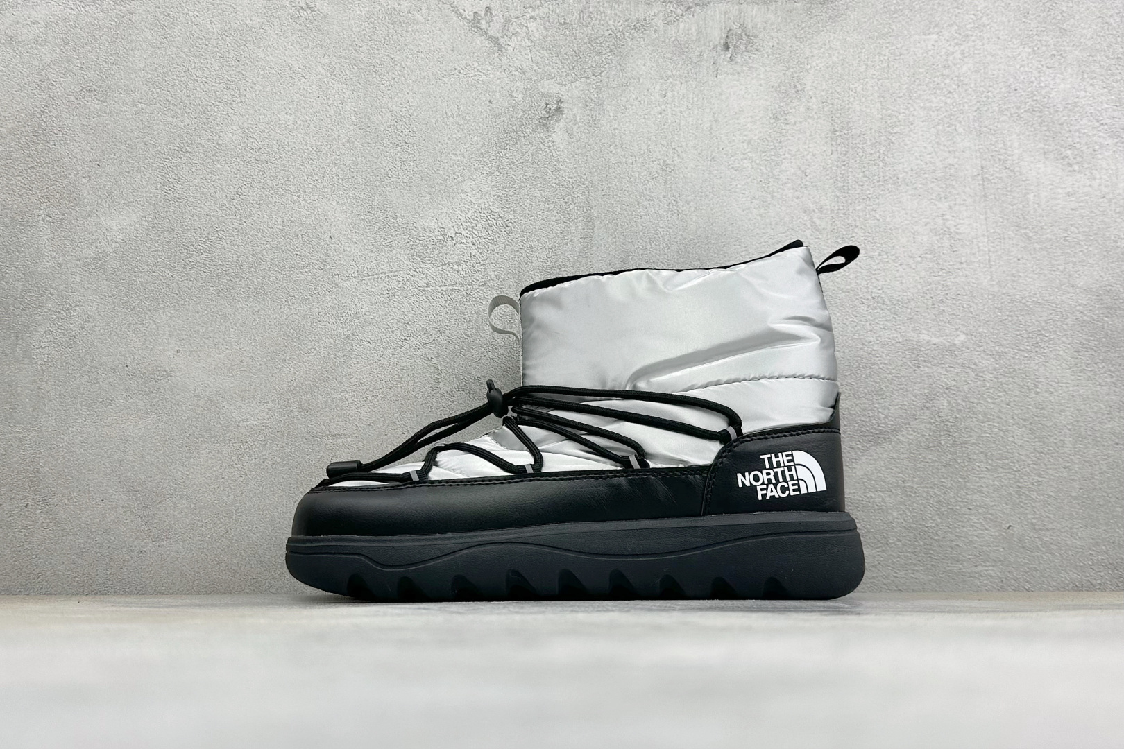 The North Face 北面高帮雪地靴，格纹尼龙防泼水面料，内里加厚绒毛，锁温保暖。快速抽绳锁扣设计，穿脱便捷，牢