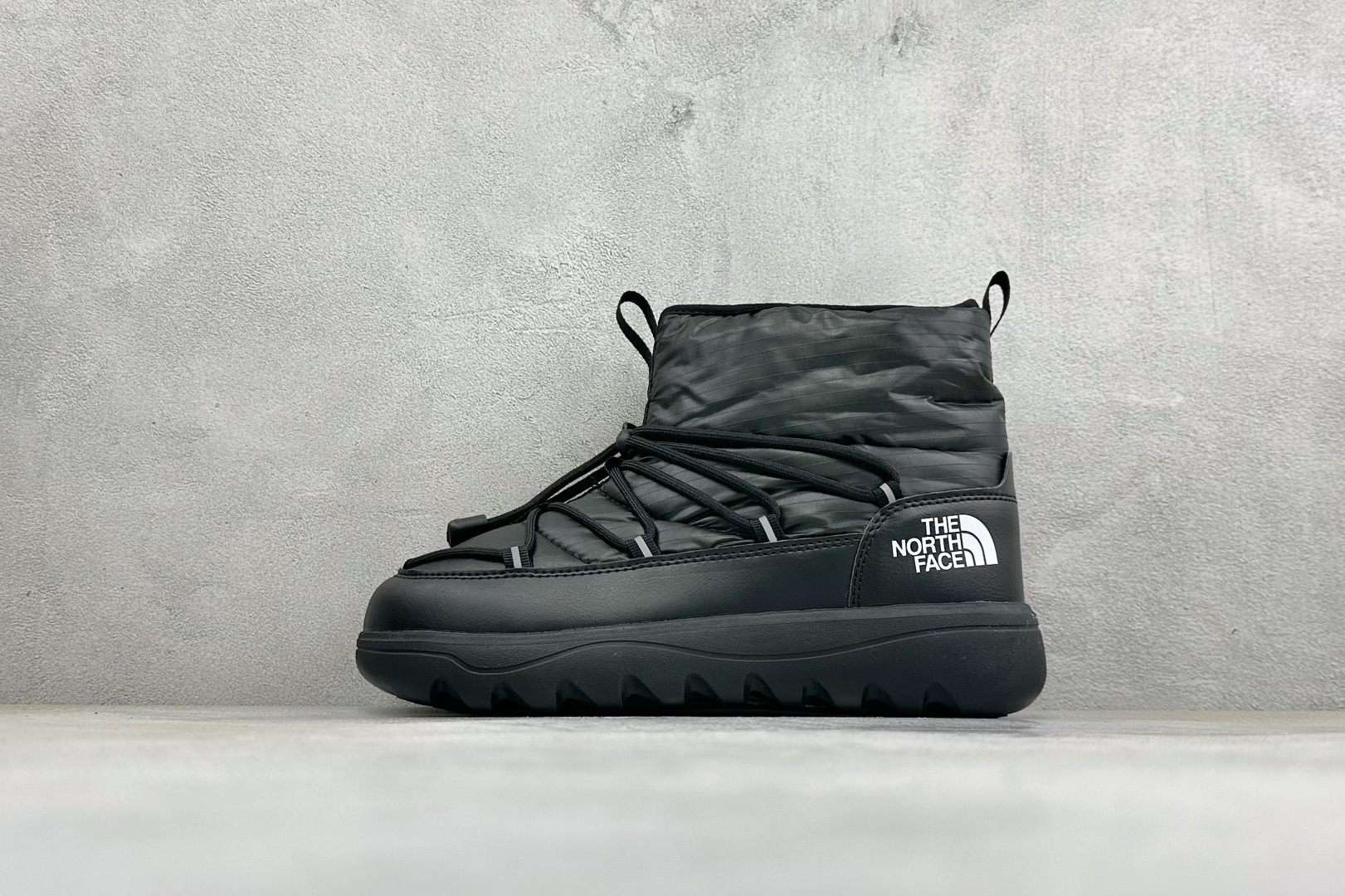The North Face 北面高帮雪地靴，格纹尼龙防泼水面料，内里加厚绒毛，锁温保暖。快速抽绳锁扣设计，穿脱便捷，牢