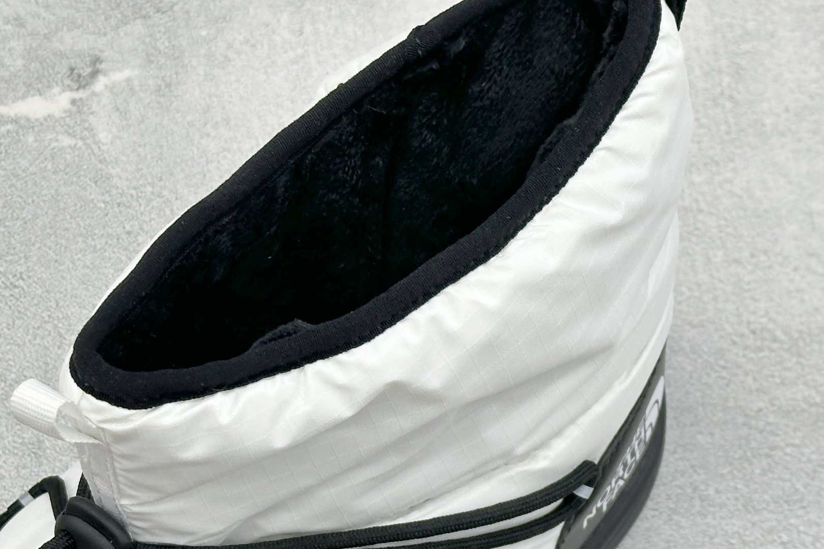 The North Face 北面高帮雪地靴，格纹尼龙防泼水面料，内里加厚绒毛，锁温保暖。快速抽绳锁扣设计，穿脱便捷，牢