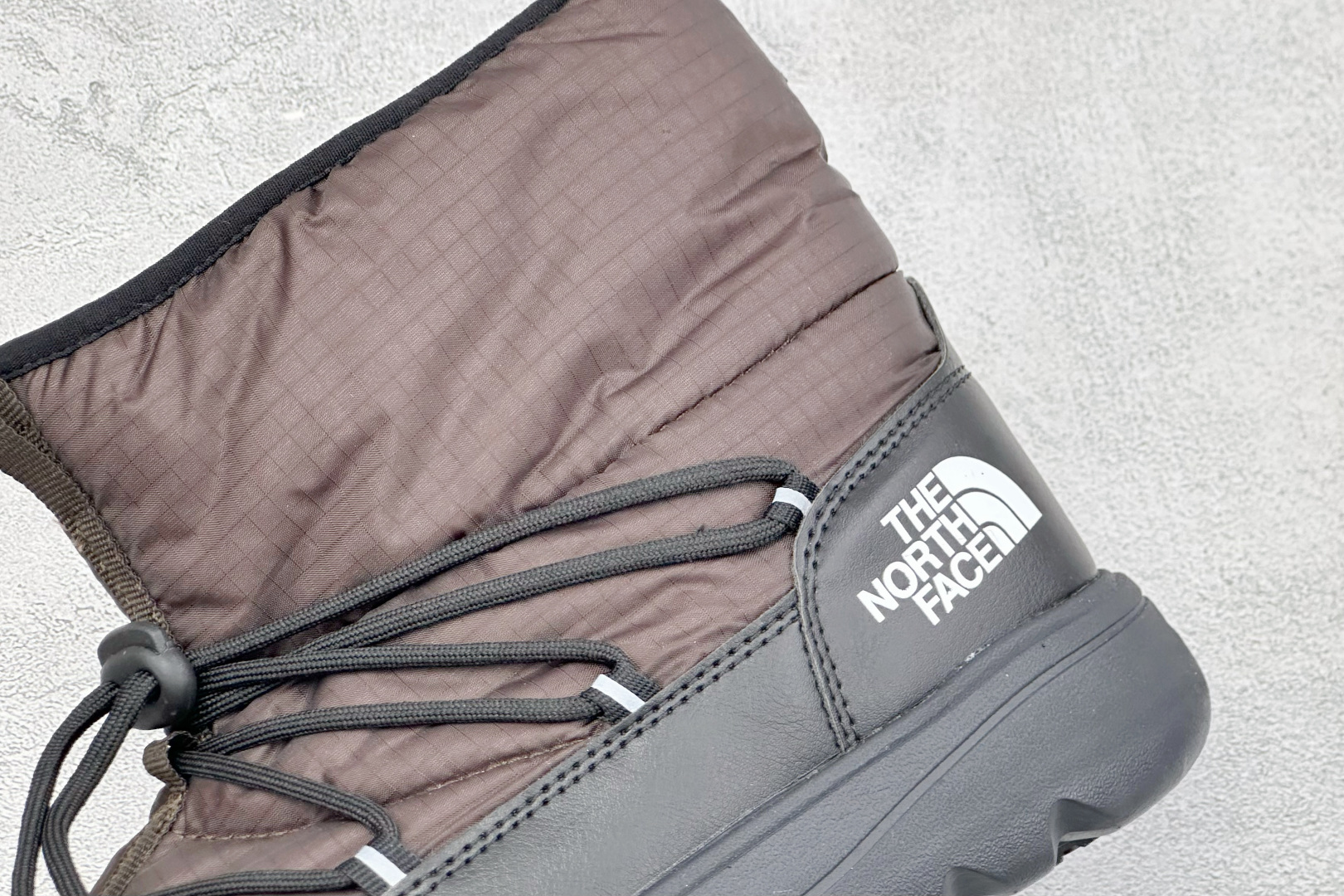 The North Face 北面高帮雪地靴，格纹尼龙防泼水面料，内里加厚绒毛，锁温保暖。快速抽绳锁扣设计，穿脱便捷，牢