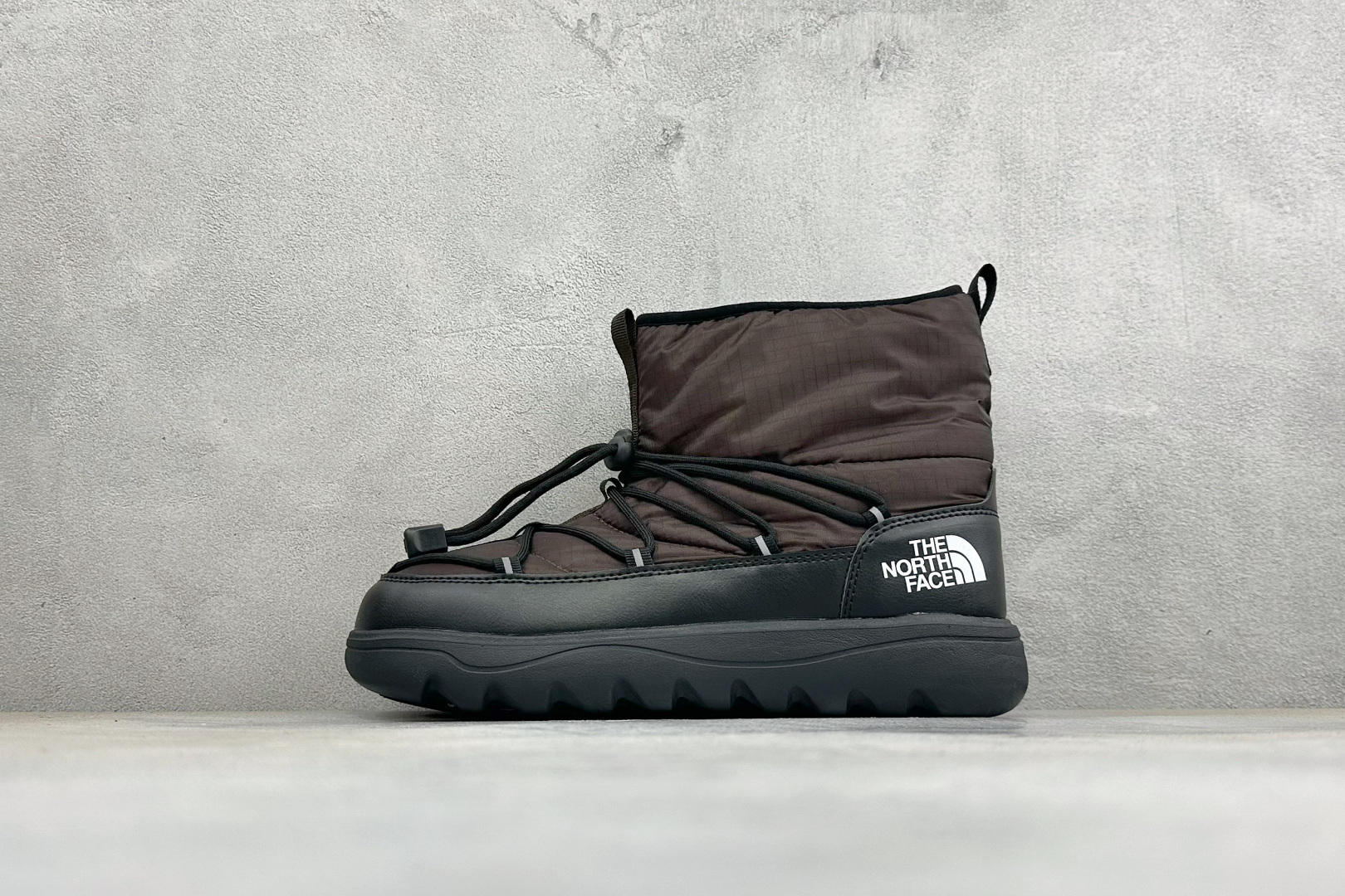 The North Face 北面高帮雪地靴，格纹尼龙防泼水面料，内里加厚绒毛，锁温保暖。快速抽绳锁扣设计，穿脱便捷，牢