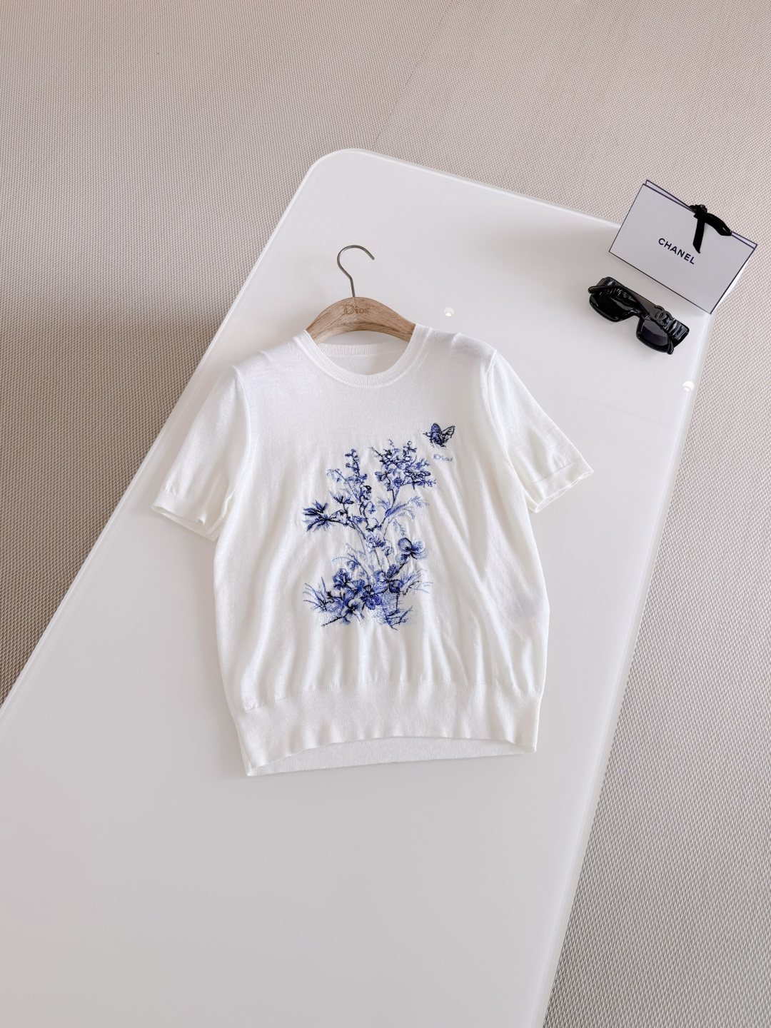 NO:799673,DIO 26S blue butterfly flower embroidered short-sleeved knitted top. Made of white sheep wool and mulberry silk blended knitted fabric. Regular fit with ribbed trim and blue Jouy print pattern embroidery. Pays tribute to flowers and nature in a poetic style,, dior, T-shirt,19860909DIO 26S 蓝色蝴蝶花卉刺绣短袖针织上衣 采用白色绵羊毛和桑蚕丝混纺针织面料 常规版型搭配罗纹饰边、蓝色茹伊印花图案刺绣 以诗意风格致敬花朵与大自然,,dior,T-shirt,,Women's clothing