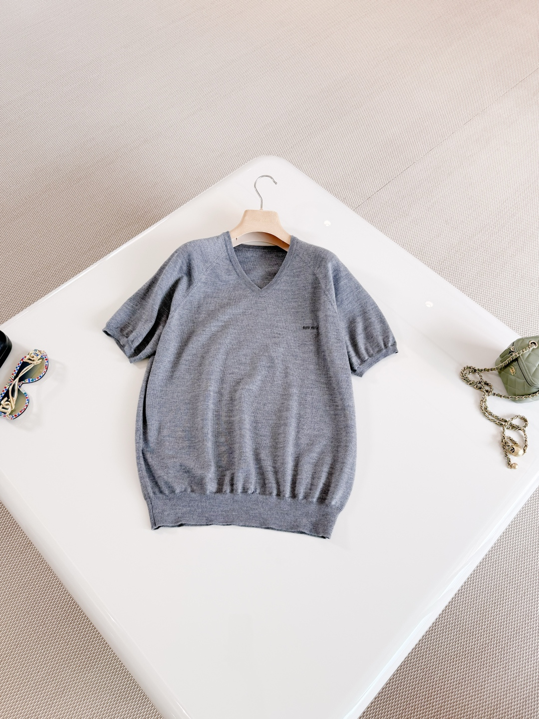 NO:802937,MIU 26W gray knitted V-neck intarsia rib T-shirt. Made of soft knitted fabric, breathable and comfortable. The V-neck design modifies the neck line and adds elegance. The slightly loose version is tolerant and can easily create a sense of relaxation. Old money style wear,,miumiu,tees,t-shirt,19860909MIU 26W 灰色针织V领嵌花罗纹T恤 采用柔软针织面料透气又舒适,V领设计修饰颈部线条增添优雅感 微宽松版型包容性强 轻松打造松弛感 老钱风穿搭,,miumiu,tees，t-shirt,,Women's clothing