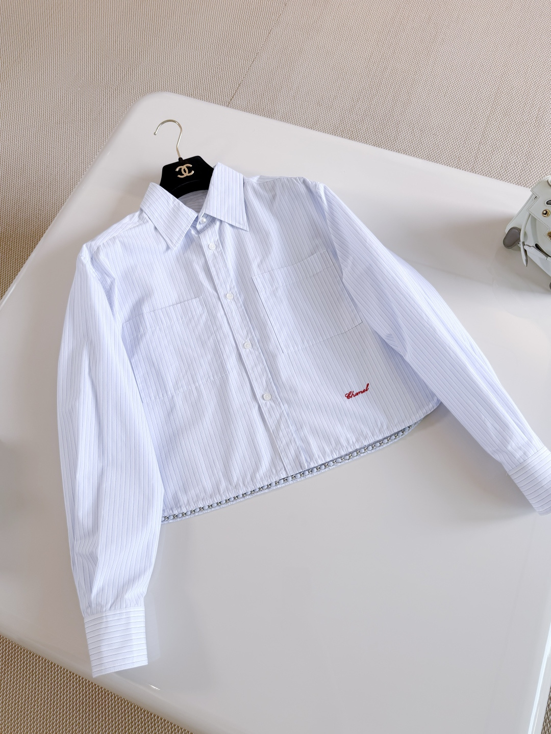 NO:857197,CHA 26S chain hem blue and white striped lapel short shirt. The blue and white vertical striped shirt is made of cotton fabric. Loose shorts design, double patch pockets on the chest + red embroidered logo is highly recognizable. The silver chain at the hem is embellished with details. Top quality,,shorts,shirts,19860909CHA 26S 链条下摆蓝白条纹翻领短款衬衫 蓝白竖条纹衬衫采用棉质面料制作 宽松短裤设计,胸前双贴袋+红色刺绣logo辨识度十足 下摆银色链条点缀细节满分 顶级品质,,shorts,shirts,,Women's clothing
