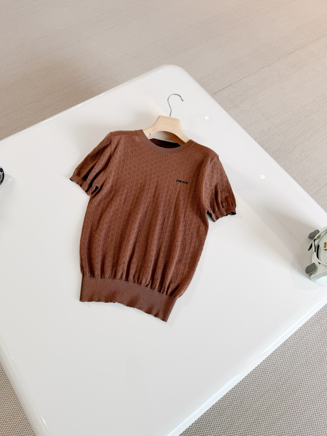 NO:860257,MIU 26S hollow pattern round neck stretch rib knit sweater. Brown knitted short sleeves. Made of cashmere fabric. Breathable and comfortable. Round neck + hollow pattern design. The brand embroidery on the chest is very recognizable. The hem is closed for a more three-dimensional effect. Top quality,,miumiu,T-shirt,19860909MIU 26S 镂空花纹圆领弹力罗纹针织衫 棕色针织短袖 采用羊绒面料制作而成 透气又舒适 圆领+镂空花纹设计,胸前品牌刺绣超有辨识度 下摆收口更显立体感 顶级品质,,miumiu,T-shirt,,Women's clothing