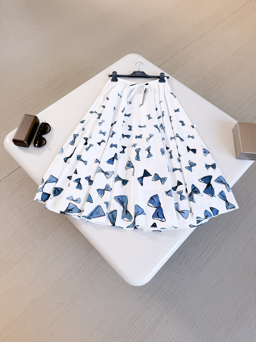 NO:865506,DIO 26W blue hand-painted bow cotton silhouette skirt. Iviera limited series blue bow pattern. Carefully crafted from white cotton poplin fabric. The flared silhouette is matched with a waist bow decorated with silver-finished metal C and D initials to enhance the style., dior, skirts,19860909DIO 26W 蓝色手绘蝴蝶结棉质廓形半裙 iviera限定系列蓝色蝴蝶结图案 采用白色棉府绸面料精心制作 喇叭形廓形搭配饰以银色饰面金属C和D首字母的腰部蝴蝶结提升格调,,dior,skirts,,Women's clothing