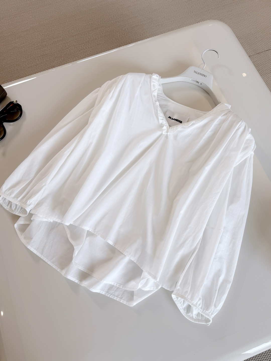NO:891062,JIL 26S Puff-sleeved ruffled V-neck cotton silhouette shirt. White V-neck loose shirt made of light cotton fabric. Breathable and comfortable. V-neck + fungus edge design, full of French elegance. Loose fit + lantern sleeves. Lazy and casual. Top quality for sale,,jil sander,shirts,19860909JIL 26S 泡泡袖荷叶边V领棉质廓形衬衫 白色V领宽松衬衫采用轻薄棉质面料 透气舒适 V领+木耳边设计,法式优雅感满满 宽松版型+灯笼袖 慵懒随性 顶级品质发售,,jil sander,shirts,,Women's clothing