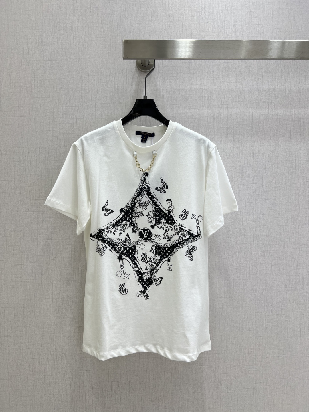 NO:487797,Highly recommended LV*2025 early autumn new round neck illustration logo chain short-sleeved T-shirt Customized YB twill cotton material breathable and comfortable, full texture Regular short-sleeved T-shirt cut highlights the brand style Made of gram-weight pure cotton, slightly elastic, presents a slim visual effect The neckline is marked with metal letters and chains in the same color thread edge as design highlights Centered iconic four-leaf clover element letter logo Three-dimensional surround illustration style flowers butterflies and other patterns Creative and artistic showing the brand's high-end feeling The youthful atmosphere has increased sharply The inner wear is brilliant and fashionable Customized surface accessories Definite version High version Two colors SML code High-quality A,,louis vuitton,T-shirt,tees,t-shirt,alexander wang19860909强烈推荐 LV*2025早秋新款 圆领插画徽标链条短袖T恤 定制YB斜纹全棉材质 透气舒适 质感十足 常规短袖T恤裁剪 凸显品牌格调 采用克重纯棉制成 略带有弹力 呈现显瘦视觉效果 领口以金属字母标链条同色系螺纹包边作设计亮点 居中标志性四叶草元素字母徽标 立体环绕插画风格的花朵蝴蝶等图案 创意和艺术性尽显品牌高级感 青春气氛骤增 单穿内搭都出彩时髦 定制面辅料 认准版本 高版本 两个色 SML码 高品质A,,louis vuitton,T-shirt,tees，t-shirt,alexander wang,Women's clothing
