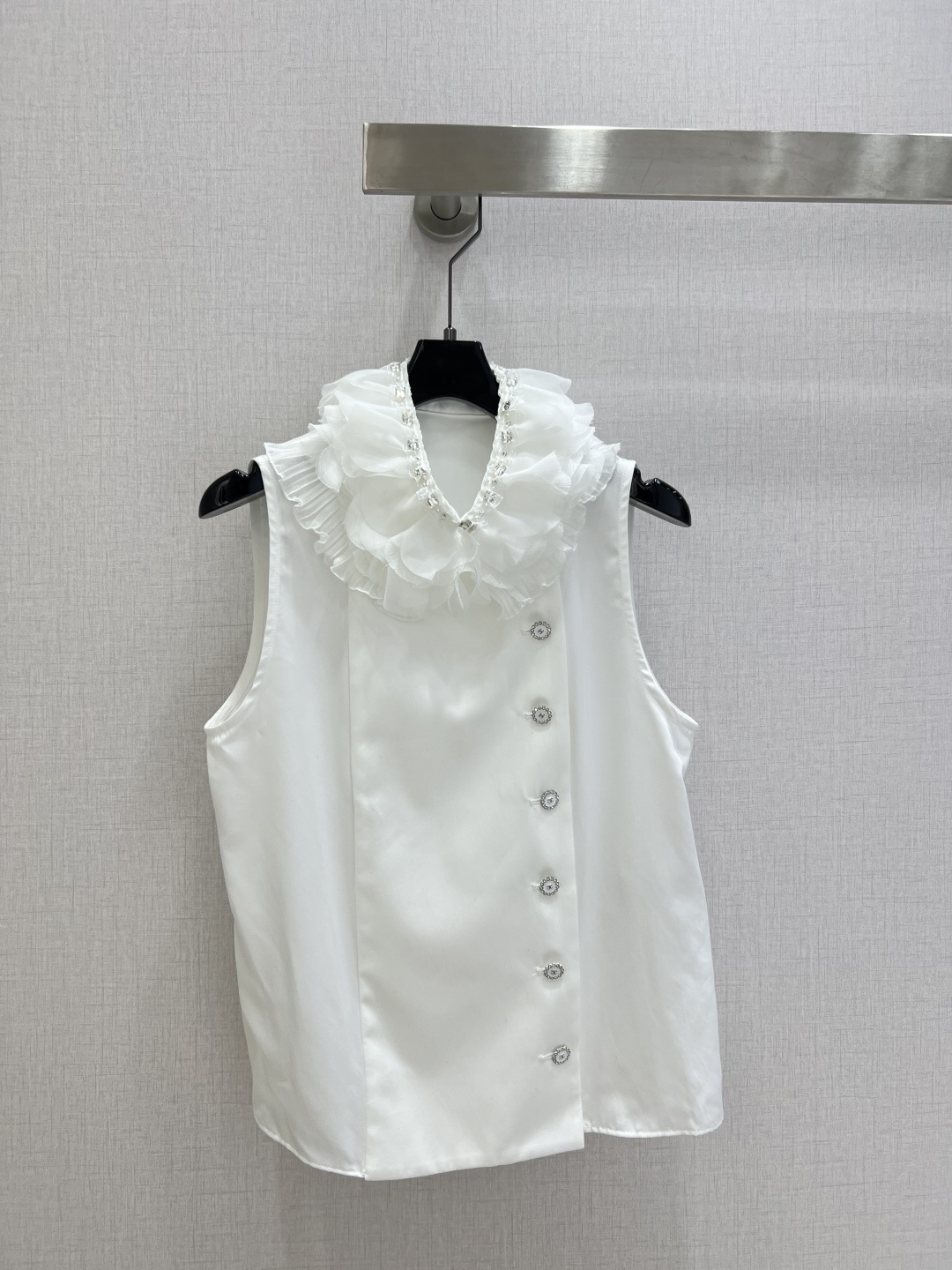 NO:731397,Highly recommended for the early spring of 26, a ruffled sleeveless shirt. A white top with a soft light filter. The neckline is layered with organza ruffles and is decorated with fine rhinestones, which look like the moonlight is rubbed into the folds. The diagonal rhinestone buttons are the finishing touch. The drapey fabric has its own coolness. The loose sleeveless version is very tolerant of the shoulder and arm lines. Wearing it alone is cool and elegant.  Stacking a suit or sweater can instantly enhance your sophistication and make you look relaxed and elegant in a crowd. SML code. High-quality ABC, shirts, business suit,19860909强烈推荐 26早春新款 荷叶边无袖衬衫 自带柔光滤镜的一件白上衣 领口层层叠叠的欧根纱荷叶边 缀着细碎的水钻 像把月光揉进了褶皱里 斜排的水钻纽扣是点睛之笔 垂坠感十足的面料自带凉感 宽松无袖版型对肩线和手臂线条都很包容 单穿清冷又贵气 叠穿西装或针织衫也能瞬间提升精致度 让你在人群里自带松弛贵气感一个色 SML码 高品质ABC,,shirts,business suit,,Women's clothing