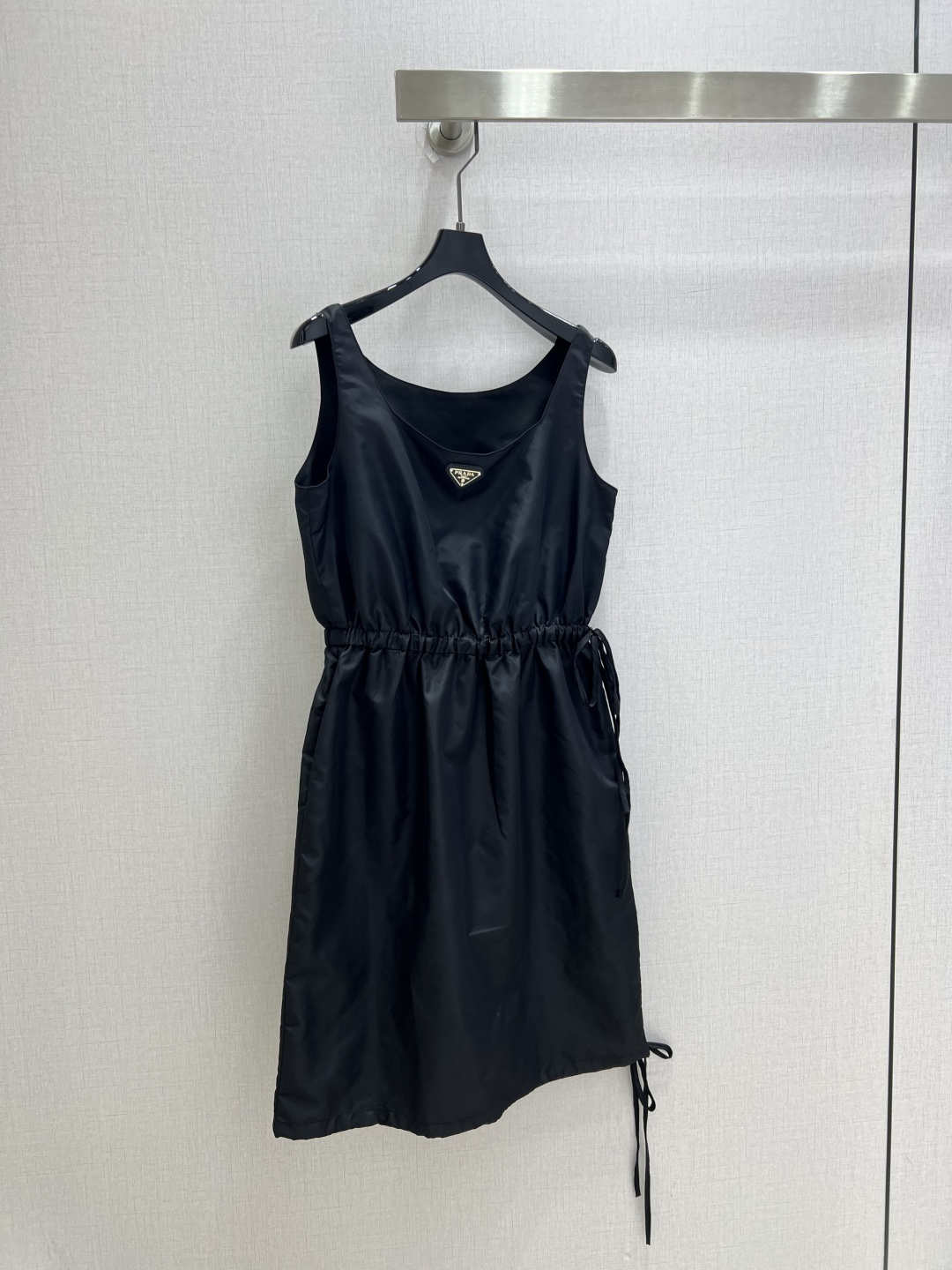 NO:902169,Highly recommended 26 spring and summer new drawstring suspender dress. Classic brand's iconic triangle logo recycled nylon fabric. The metal triangle logo on the chest is engraved with the brand's tone in a low-key manner. The elastic drawstring around the waist can be cinched at will. The loose bud skirt gently hides the fat on the waist and abdomen. It accommodates all kinds of body shortcomings. The double drawstring design on the side and hem of the skirt hides ingenuity. Tighten the hem to switch to a short and flexible version.  Easily create an effortless, advanced sense of relaxation. One color SML code. High quality,,skirts,19860909强烈推荐 26春夏新款 抽绳吊带连衣裙 经典品牌标志性三角标再生尼龙面料 胸前金属三角徽标低调镌刻品牌调性 腰部整圈松紧抽绳随心收束腰线 松弛花苞裙摆柔和藏住腰腹赘肉 包容各类身材短板 裙身侧边与下摆双抽绳设计暗藏巧思 收紧下摆可切换短款灵动版型 轻松打造不费力的高级松弛感 一个色 SML码 高品质,,skirts,,Women's clothing