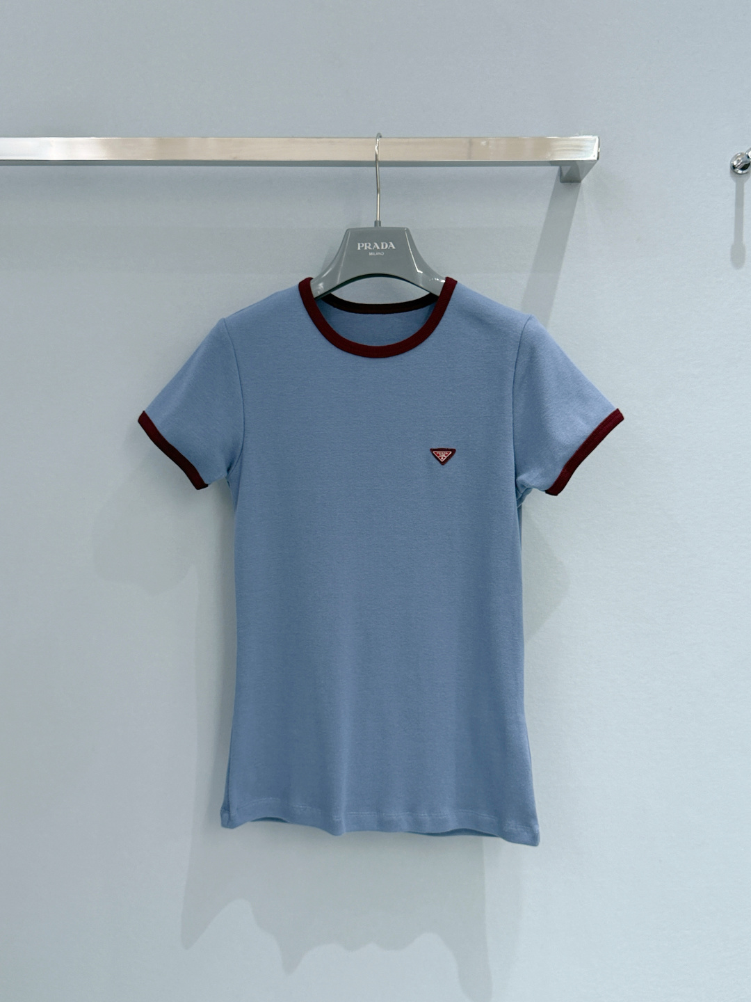 Prada26新款雾霾蓝撞色边针织短袖T恤，面料为100%棉，亲肤透气且带有细腻肌理，领口与袖口的酒红色