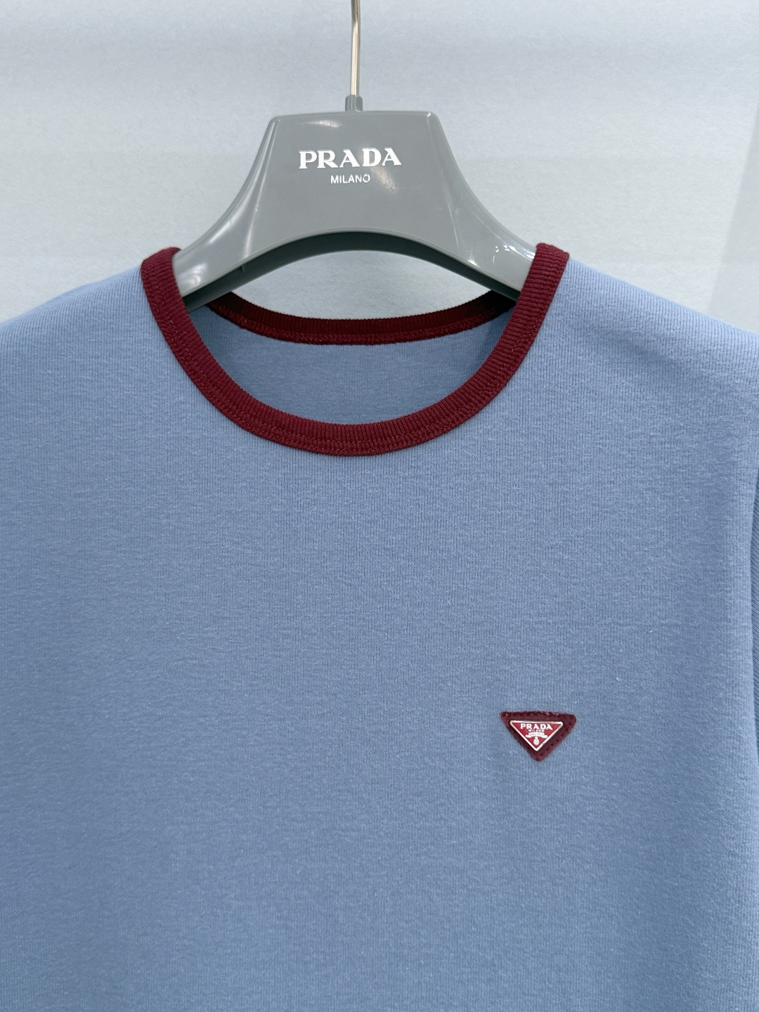 Prada26新款雾霾蓝撞色边针织短袖T恤，面料为100%棉，亲肤透气且带有细腻肌理，领口与袖口的酒红色