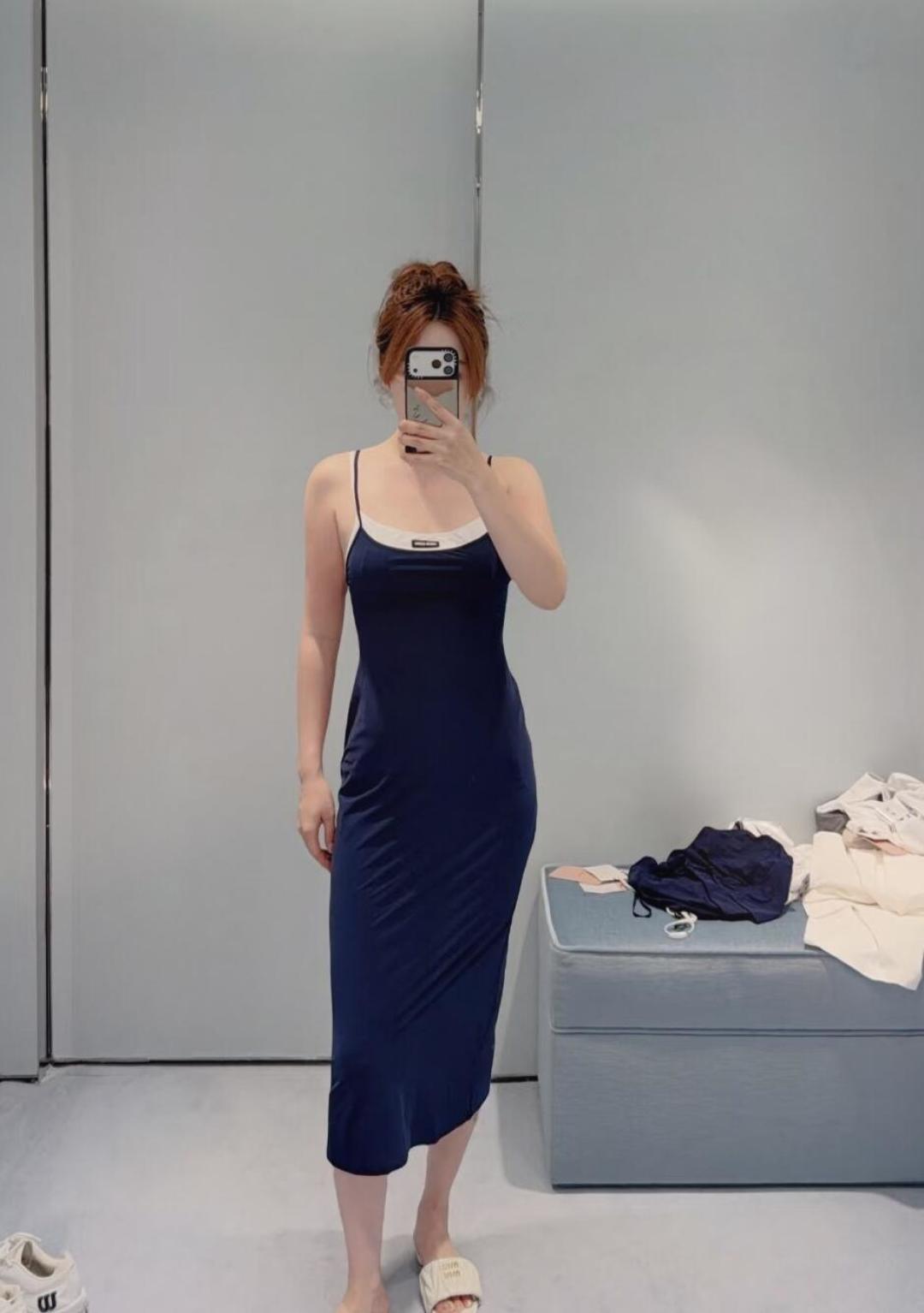 NO:908314,Miu Miu  26's new fake two-piece swing collar suspender long dress, with deep navy as the main tone, and an off-white inner layer, creating a very layered visual effect. This dress is made of a blended fabric of 73 recycled nylon and 27 spandex, which not only fits the body shape and is elastic, but also reflects the brand's positive response to sustainable fashion. The spaghetti strap design is simple and exquisite, and the slightly swinging neckline cleverly modifies the neck line, revealing a trace of laziness and sexiness.  ; The slim straight long skirt is cut and draped smoothly, which can well outline the body curve, making it look tall and elegant. Whether worn alone to show French romantic style, or paired with a suit jacket to cope with the temperature difference between morning and evening, it is a wardrobe essential that has both design and practicality, allowing you to easily exude the charming Miu charm while walking in the city. Sizes SML,,miumiu,skirts,jackets  & coats, business suits,19860909Miu Miu 26新款假两件荡领吊带长裙,以深邃的藏青色为主调,搭配内层的米白色打底,营造出极具层次感的视觉效果.这款连衣裙采用了73再生锦纶与27氨纶的混纺面料,不仅贴合身形、富有弹性,更体现了品牌对可持续时尚的积极响应.细肩带设计简约精致,微荡的领口巧妙修饰颈部线条,流露一丝慵懒与性感；修身的直筒长裙剪裁流畅垂坠,能够很好地勾勒出身材曲线,既显高挑又优雅大方.无论是单穿展现法式浪漫风情,还是搭配西装外套应对早晚温差,它都是一件兼具设计感与实穿性的衣橱必备单品,让你在都市漫步中轻松散发迷人的Miu系魅力.尺码SML,,miumiu,skirts,jackets & coats,business suit,,Women's clothing