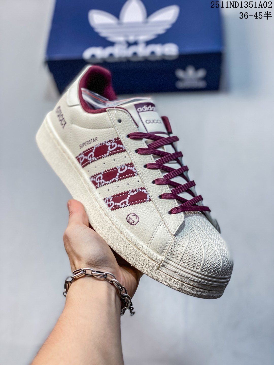 公司级 高端定制adidas Superstar 斯图西联名-白蓝 延续 Adidas 标志性贝壳头,以米白为主调的鞋身,宛如复古画报的底色,质感皮质细腻又挺括,复刻着半个世纪前的经典廓形.三道杠缀满蓝白涂鸦纹理,是 Stüssy 标志性的艺术表达;鞋舌、后跟的深海蓝撞色,像街头潮人随性搭的配饰,还有专属金属三叶草挂饰 高端定制 低帮休闲板鞋 定制鞋盒 大厂品质出货 超高清洁度 皮料切割干净无任何毛边 细节完美 货号:XG0009 ND1351A02