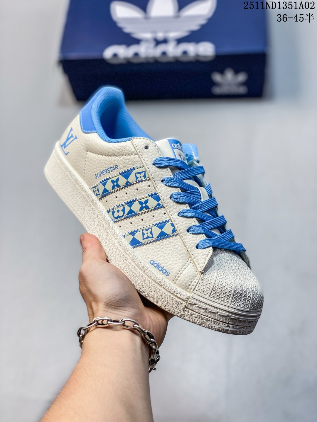 公司级 高端定制adidas Superstar 斯图西联名-白蓝 延续 Adidas 标志性贝壳头,以米白为主调的鞋身,宛如复古画报的底色,质感皮质细腻又挺括,复刻着半个世纪前的经典廓形.三道杠缀满蓝白涂鸦纹理,是 Stüssy 标志性的艺术表达;鞋舌、后跟的深海蓝撞色,像街头潮人随性搭的配饰,还有专属金属三叶草挂饰 高端定制 低帮休闲板鞋 定制鞋盒 大厂品质出货 超高清洁度 皮料切割干净无任何毛边 细节完美 货号:XG0009 ND1351A02