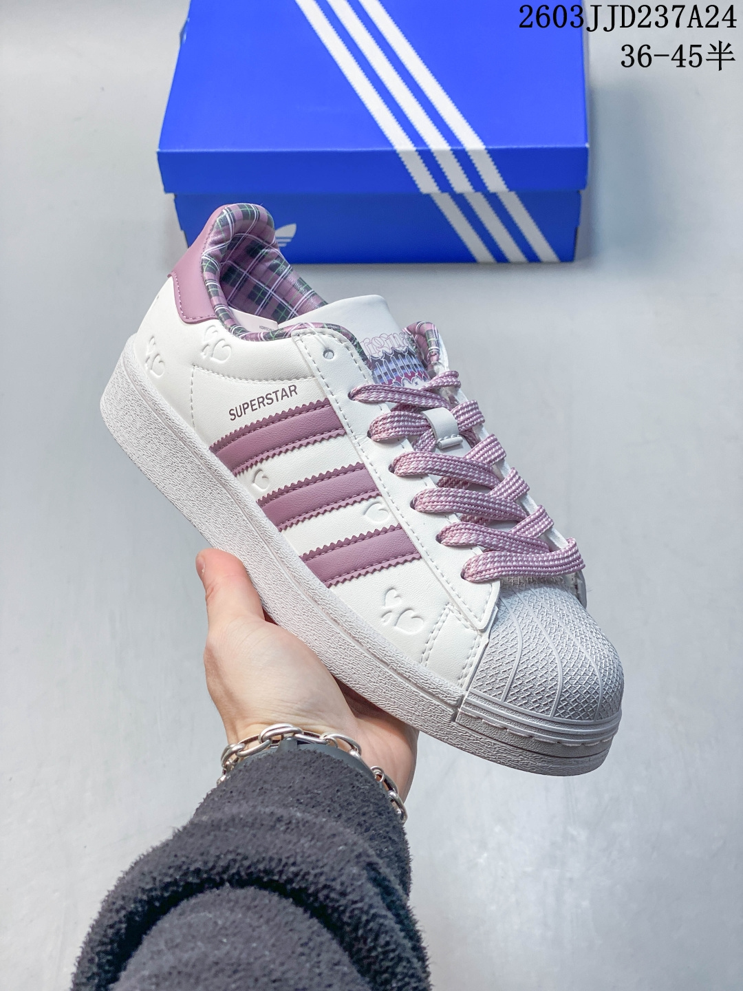 真标带半码 Adidas Original Superstar 2 阿迪达斯 低帮 情人节限定 白紫 男女同款 贝壳头2代防滑耐磨轻便低邦板鞋 鞋身整体以白色皮革打造,搭配经典白色贝壳头,鞋身两侧经典锯齿三条杠Logo采用紫色皮革点缀,侧身Superstar字样黑色压印妆点,鞋身小爱心压纹细节、紫色格纹内衬、后跟不对称的火焰爱心和玫瑰刺绣,瞬间提升鞋子的时尚程度,最后白色中底搭配同色系橡胶外底完善整体设计收尾. 货号:KZ7157(2026.01.26发售) 2⁄3 36 362⁄3 371⁄3 38 382⁄3 391⁄3 40 402⁄3 411⁄3 42 422⁄3 431⁄3 44 442⁄3 451⁄3 编码:120022 B 03JJD237A24