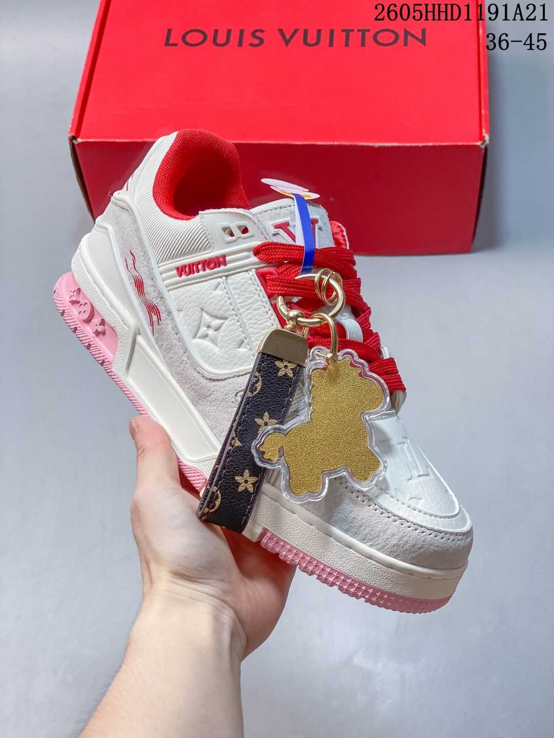 LV TRAINER粉白灰(中国红限定礼盒-钥匙扣丢失扣30元) 26年限定中国红礼盒及全套包装说明书防尘布袋物件，完美楦型，独家开模定制！ trainer这个系列是路易威登融合街头潮流与高时装的标志性之作。在材料选用上，鞋面采用Monogram印花与Monogram压纹粒面牛皮革的搭配，呈现出独特的复古韵味。荔枝纹粒面头层牛革鞋面，触感细腻且富有韧性，自带自然的皮革纹理，彰显高质感，为鞋子增添了丰富的层次感。鞋垫采用超软乳胶材质，零磨合不磨脚，软乎乎的皮质包裹感超棒，鞋底则采用橡胶材质，刻有经典的Monogram花卉纹路，不仅防滑，还带走缓震效果还极具设计感。做工方面，TRAINER系列板鞋展现了精湛的工艺水准。鞋头采用圆润设计，空胶工艺搭配包边工艺，不仅美观，还能有效防踢蹭。鞋舌、侧面和后部饰有LV字母，侧面还有Vuitton标识，均做工精细，彰显品牌身份。鞋身走线工整均匀，看不到任何多余的线头，皮革的拼接处也处理得极为细腻，体现了我们对细节的极致追求。百搭属性直接封神！配牛仔裤是复古街头风，搭西装裤秒变松弛通勤感，甚至配半身裙都甜妹感拉满，堪称"衣柜万能钥匙"。这双集颜值、质感、实穿性于一体的奢牌板鞋！ 货号：2A8DM7VL 尺码/SIZE：36 37 38 39 40 41 42 43 44 45（不带半 05HHD1191A21 image 1