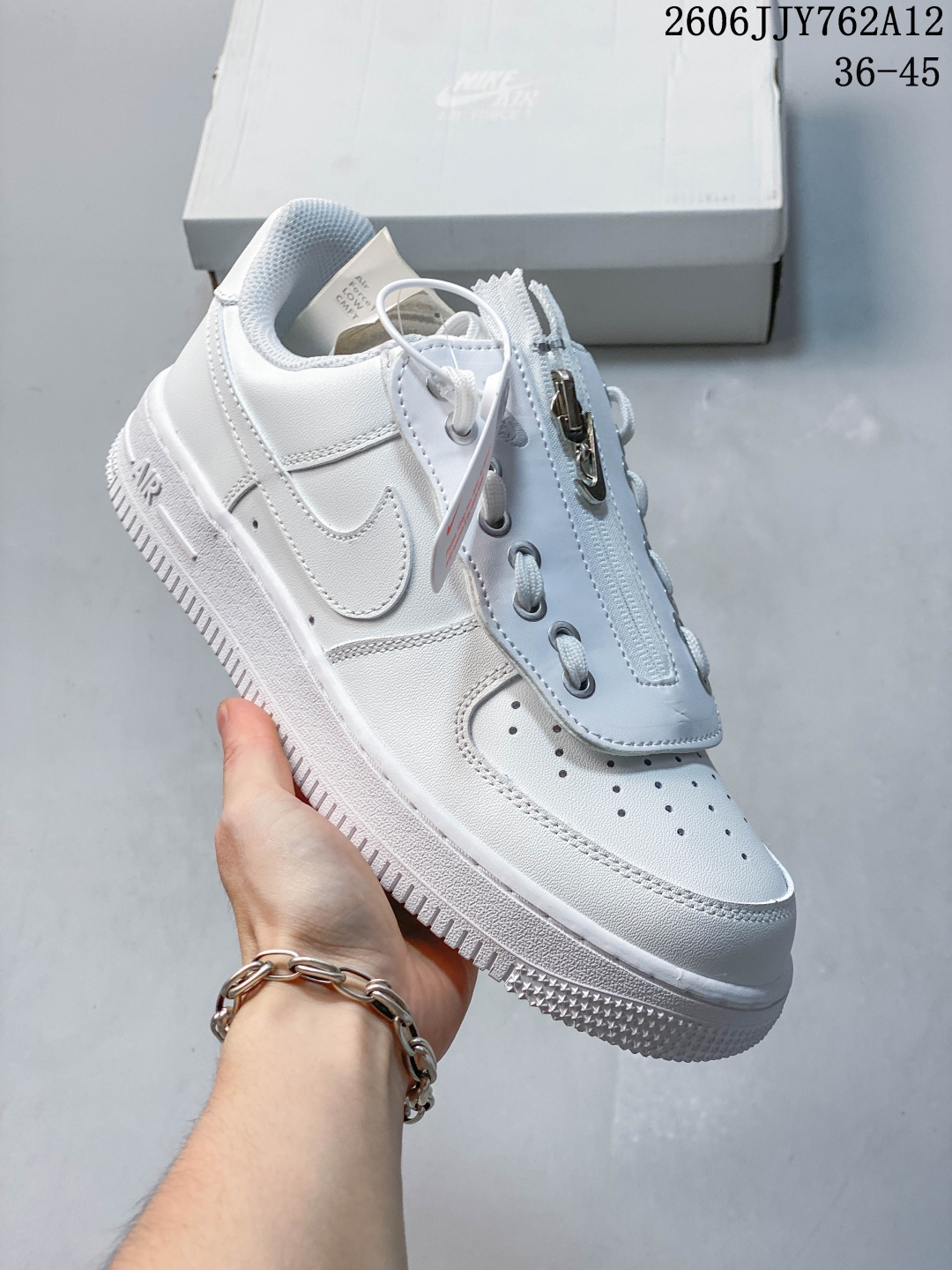 Nike Air Force 1 '07 Shroud（型号 DC8875-100），属于经典空军一号的特殊设计 1. 拉链式“Shroud”鞋盖 这是它最标志性的设计：鞋舌位置增加了一块带拉链的可开合鞋盖，能直接盖住传统鞋带，打造“无鞋带”的利落效果；鞋盖内侧还有一个迷你Swoosh标志，细节感拉满。 2. 全白皮革鞋面 采用光滑的纯白皮革打造，搭配金属质感的拉链和鞋带孔，既保留了AF1的简约经典，又通过机能风元素增加了辨识度。 3. 隐藏式鞋带设计 鞋盖下的鞋带是隐藏式的，日常穿着时可以拉上拉链，呈现极简的一体化鞋面；也可以拉开拉链，搭配不同鞋带穿出多种风格。货号:CW2288-111 Size:36～45 06JJY762A12 image 1