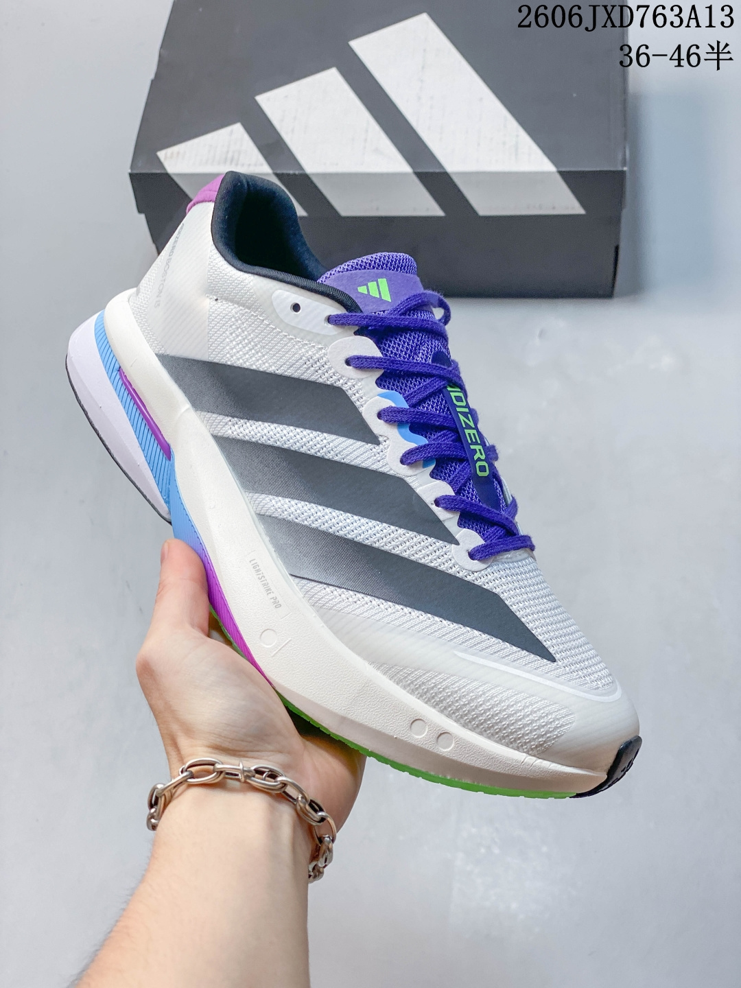 ADIZERO BOSTON 13（波士顿13） 竞训跑鞋，1. 缓震与推进 - 搭载 Lightstrike Pro 中底，兼顾回弹与稳定性，后跟缓震比前代明显增强。 - 内置 ENERGYRODS 2.0 玻纤柱，提供自然的推进力和中足支撑，比碳板更适合日常训练和进阶跑者。 2. 鞋面与包裹 - 工程网布鞋面，透气且轻量化，鞋头压胶提升耐用性。 - 鞋舌与后跟内衬填充更足，锁定感和舒适度提升，鞋型偏窄，宽脚建议选大。 3. 抓地与耐用 Lighttraxion 外底搭配 Continental™ 马牌橡胶，干湿路面抓地力优秀，耐磨表现也比上一代更好。 货号：JS4946 鞋码：36-46 06JXD763A13 image 1