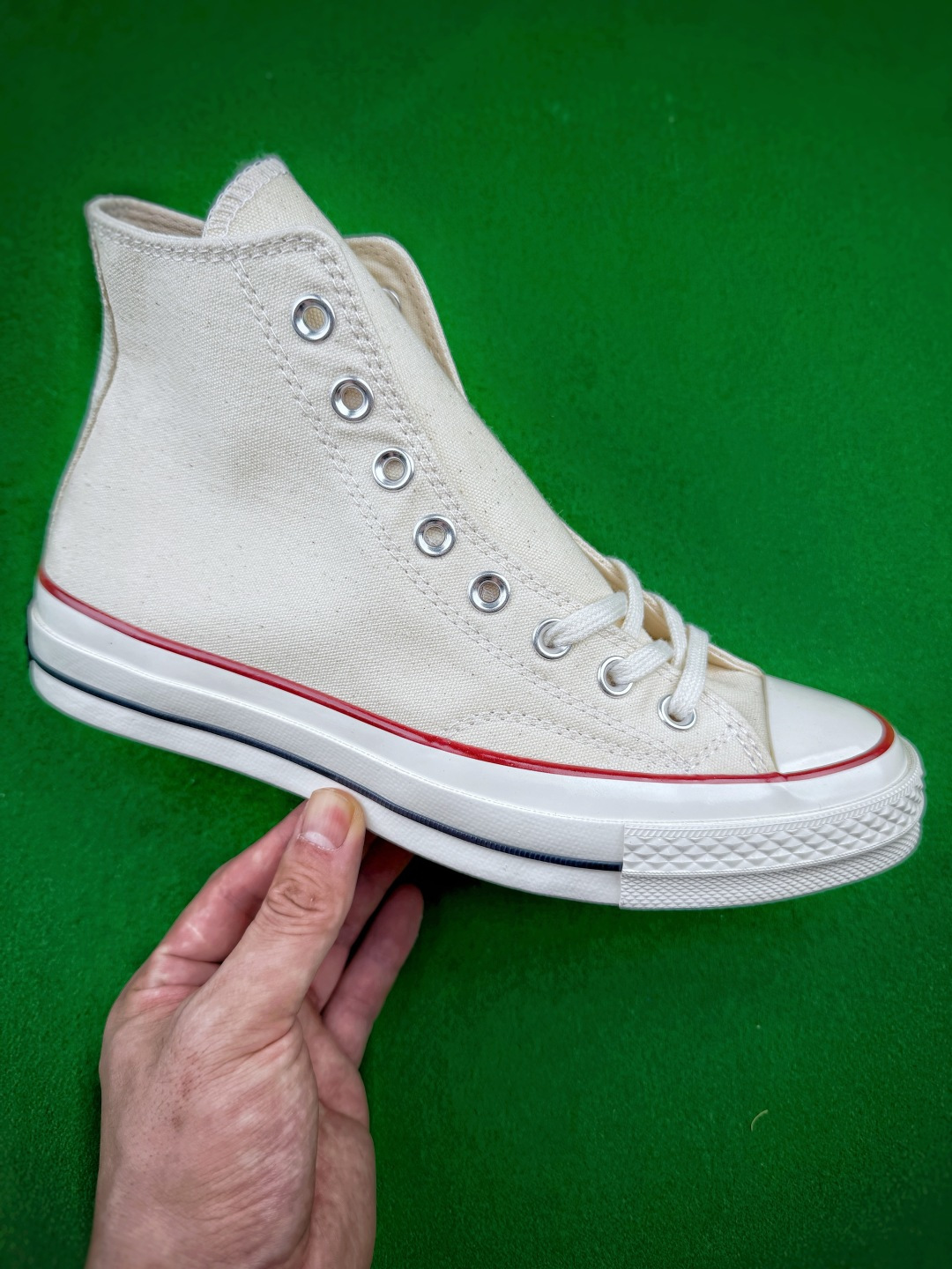虎扑 区别市面通货 双围条小头Converse Chuck 70高帮帆布鞋，采用扎实耐磨的帆布打造鞋身，经典高低帮版型可以修饰腿部线条，金属鞋眼搭配棉质鞋带，穿脱灵活且贴合脚面，鞋头采用橡胶包头，有效防磕碰，鞋身保留标志性明线车缝工艺，细节质感突出。中底搭载加厚橡胶结构，脚感柔软，缓震表现优于基础款，侧边饰有细黑线条，外底是标志性的菱形颗粒橡胶纹路，防滑耐磨，兼顾日常行走的实用性，复古的版型适配多种穿搭风格，，不管是日常通勤、休闲出街都很合适，长久穿着不易快速疲劳，是百搭耐看的经典复古帆布鞋。Size 35 36 36.5 37 37.5 38 39 39.5 40 41 41.5 42 42.5 43 44 45 46 image 1